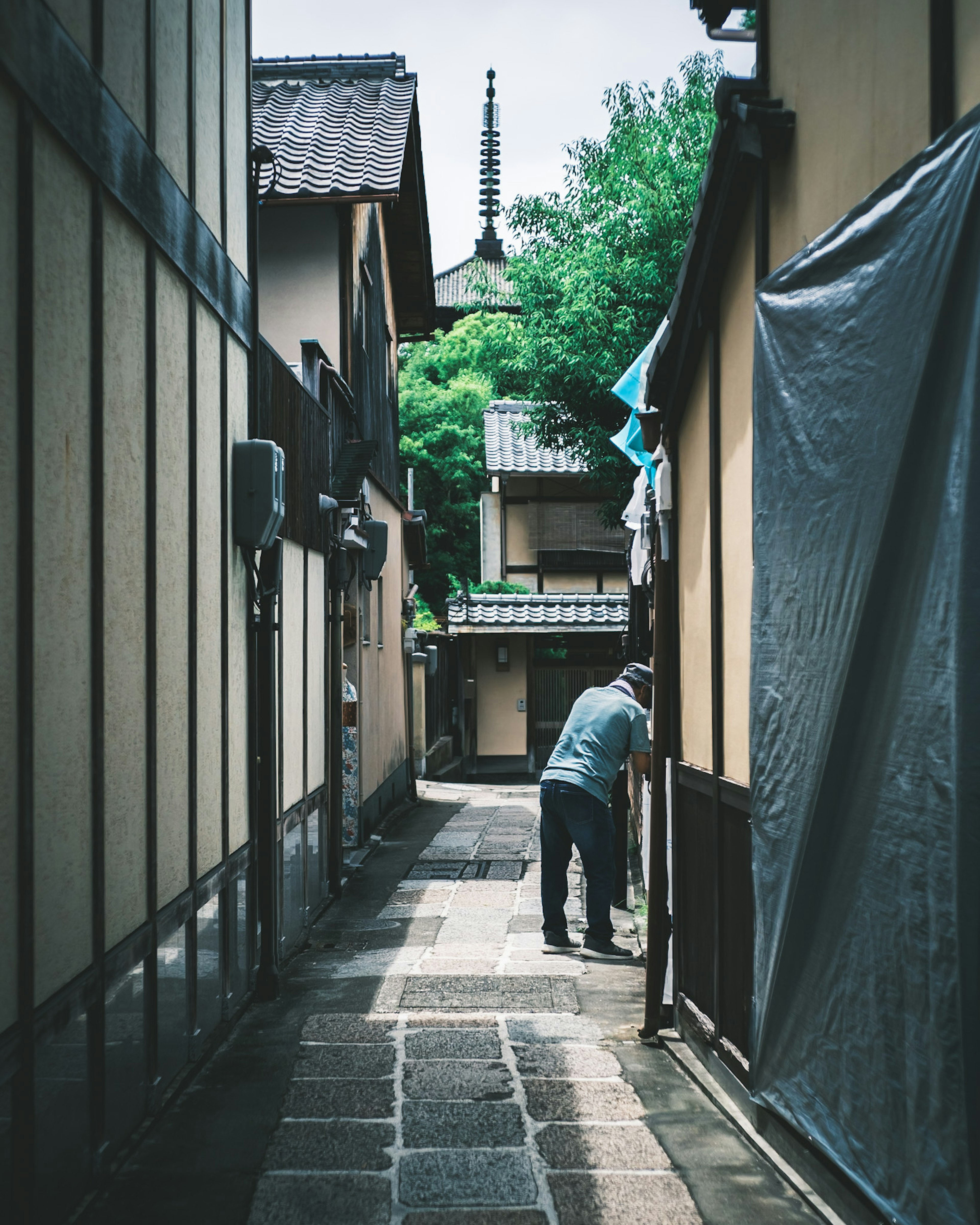 狭い路地に立つ男性と古い建物がある風景