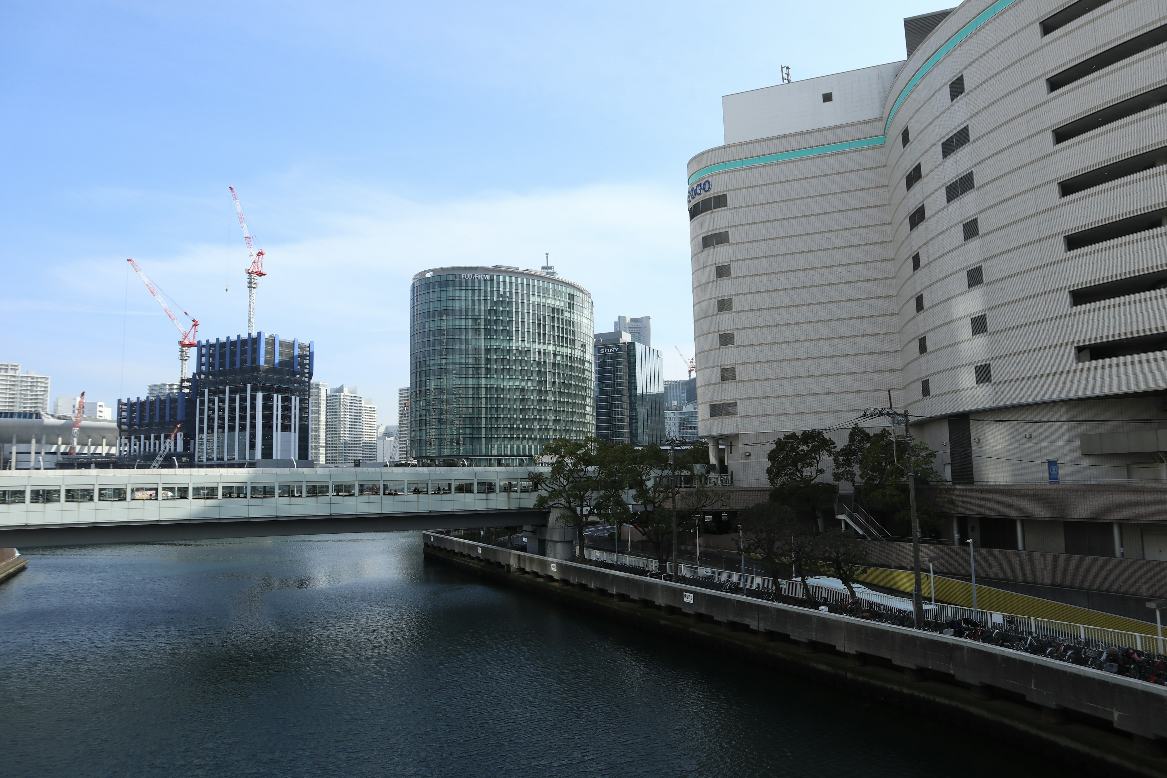 Modern buildings along a river with a clear blue sky