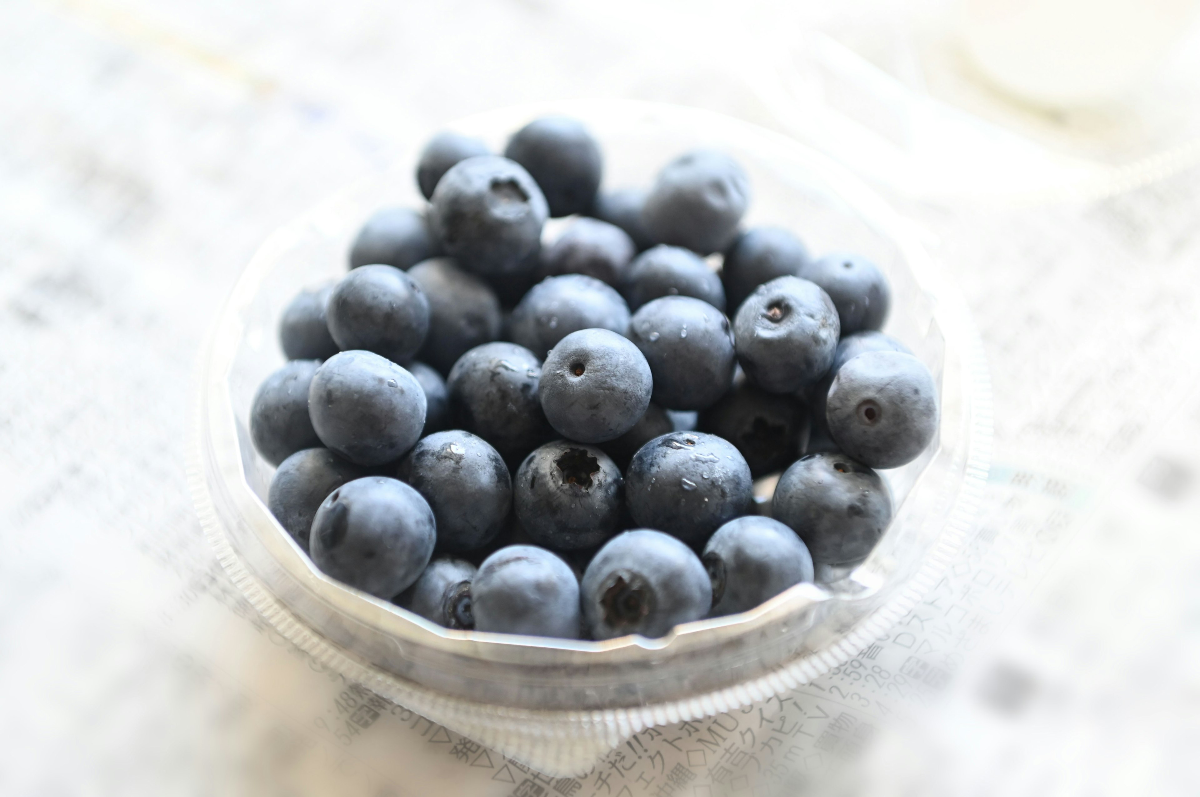 A bowl of fresh blueberries on a light background