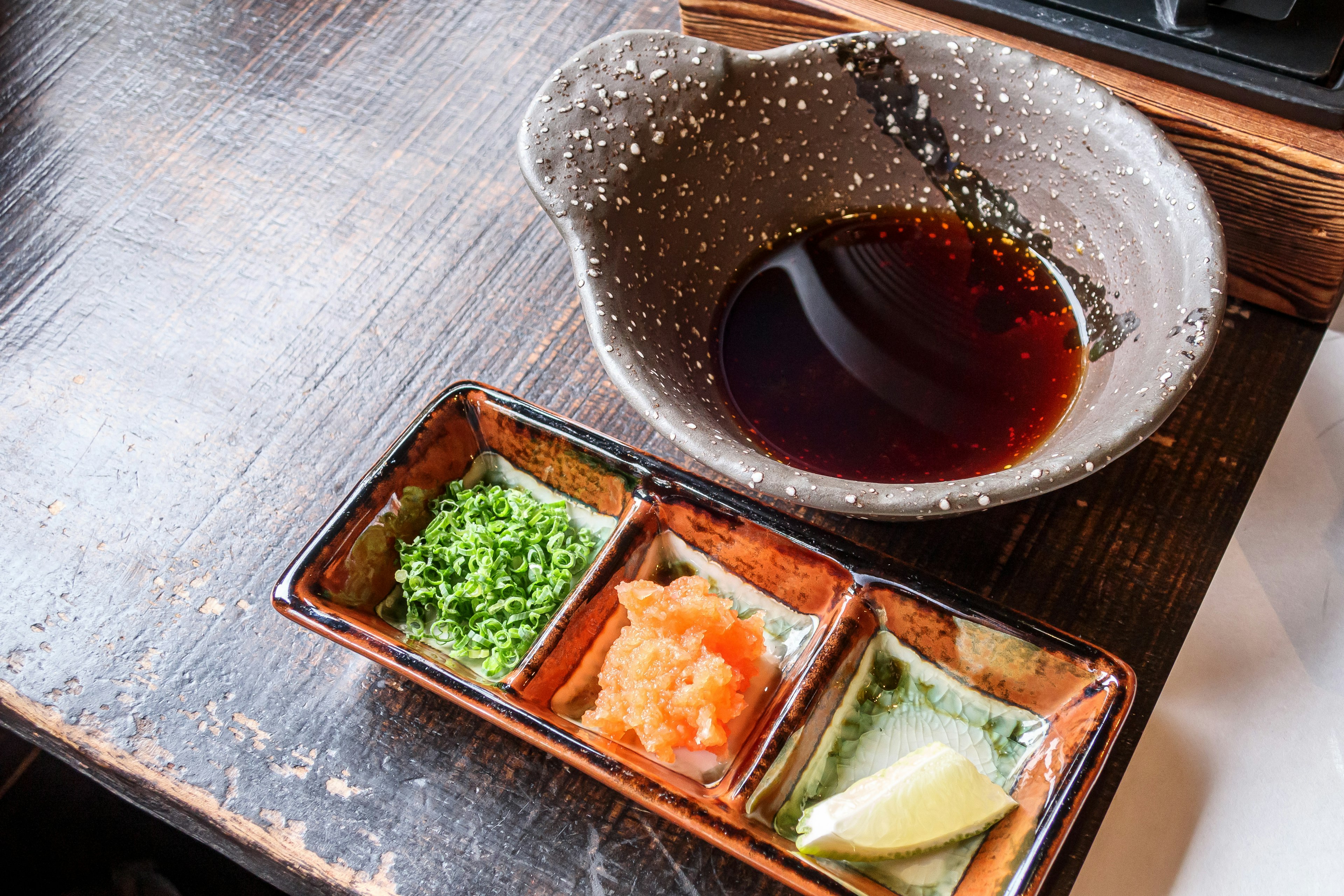 Hidangan Jepang yang stylish dengan bumbu hijau telur ikan oranye dan seiris lemon