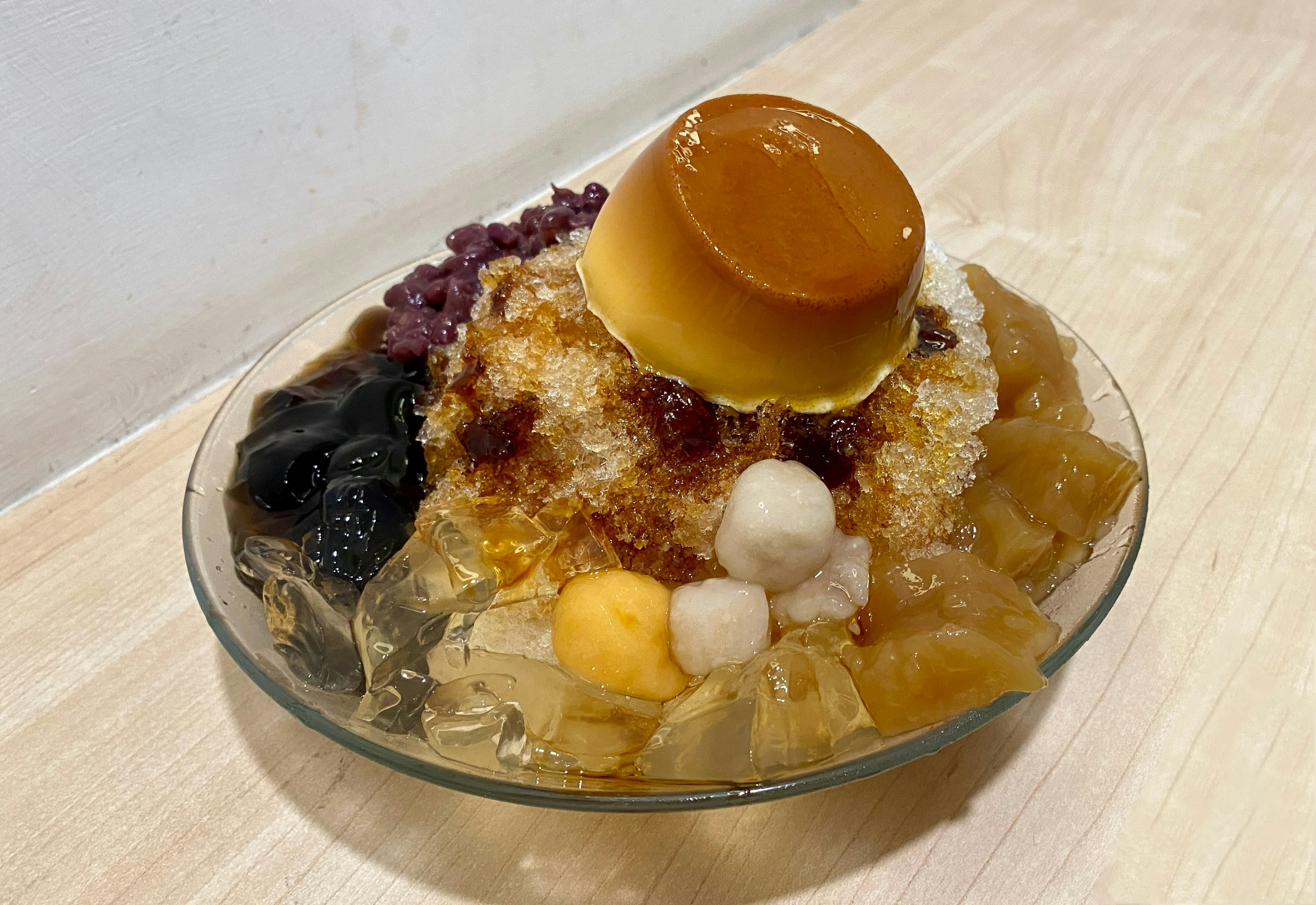 Bol de dessert coloré avec panna cotta, glace pilée et fruits variés