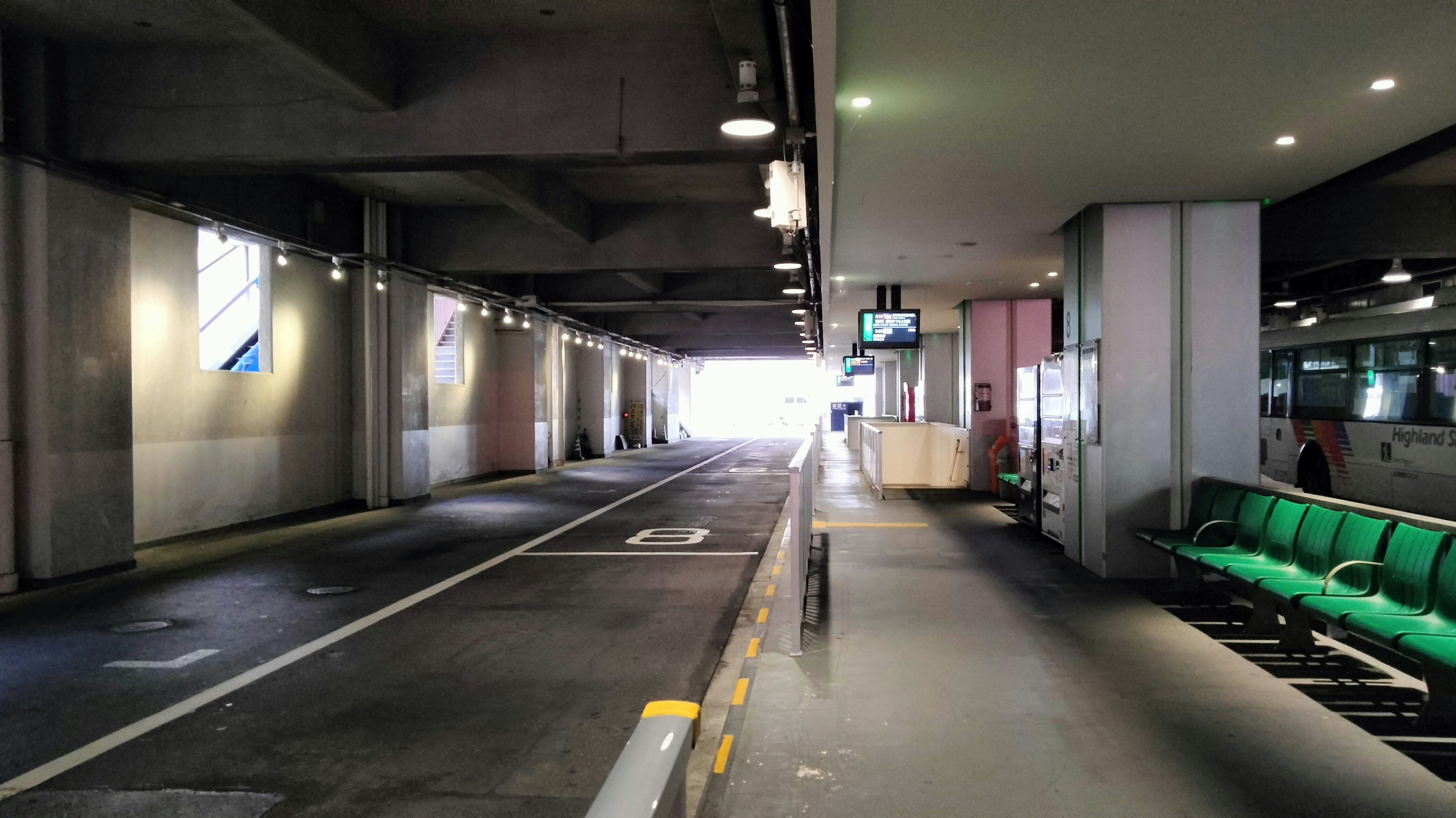 Couloir lumineux d'un passage souterrain avec des bancs verts