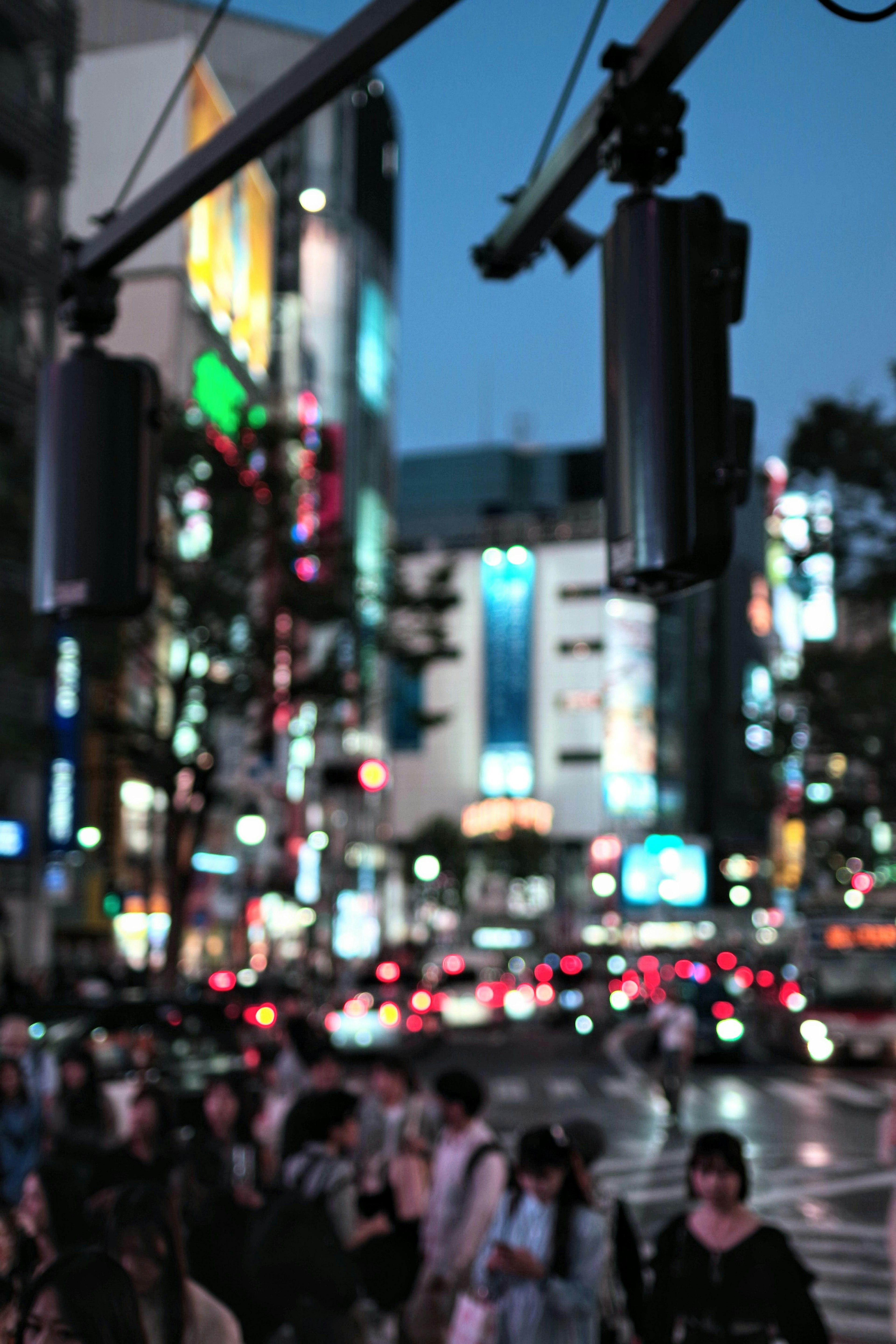 Night cityscape featuring traffic lights and crowd of people