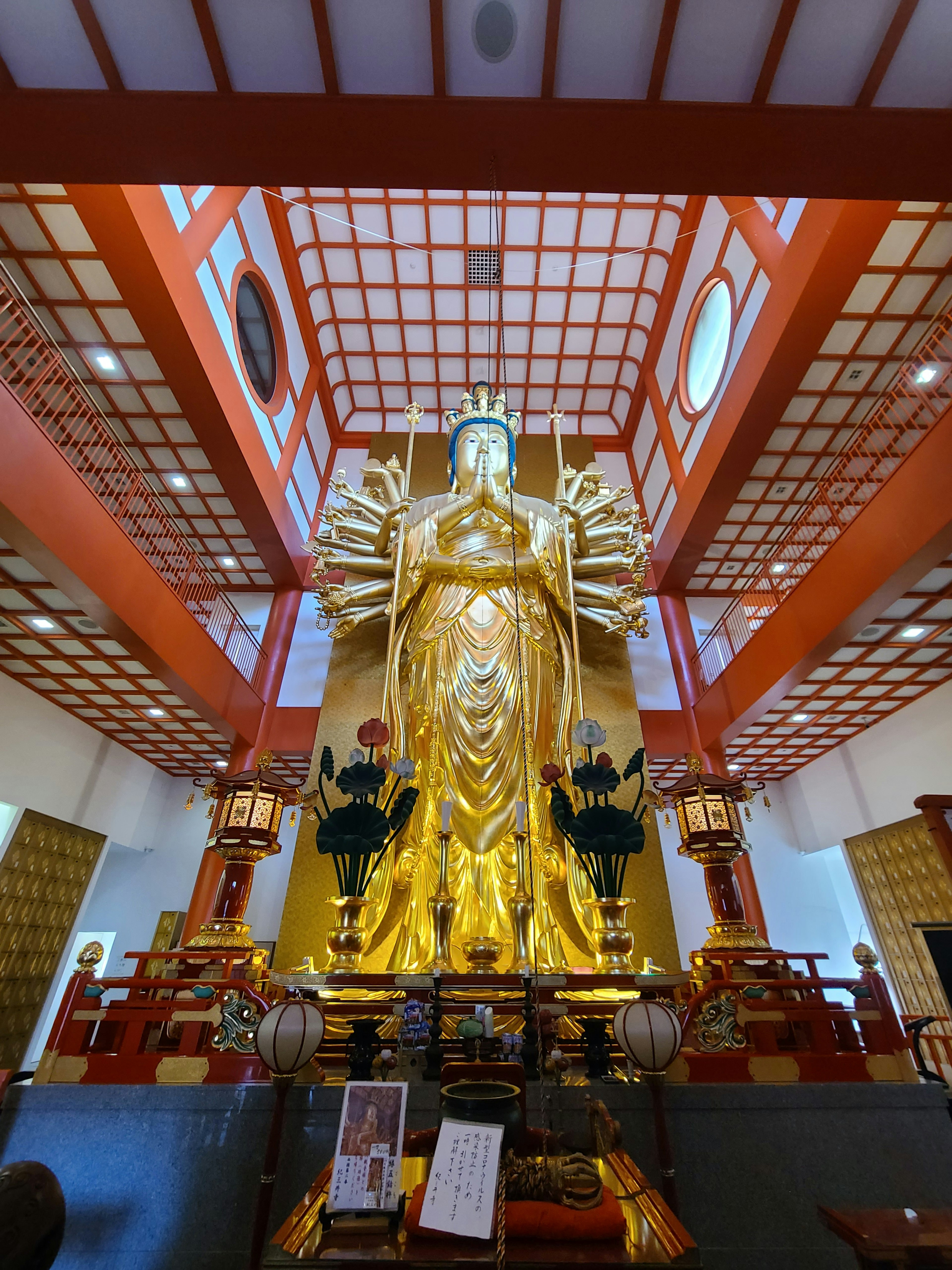 Golden Buddha statue towering inside a beautiful temple