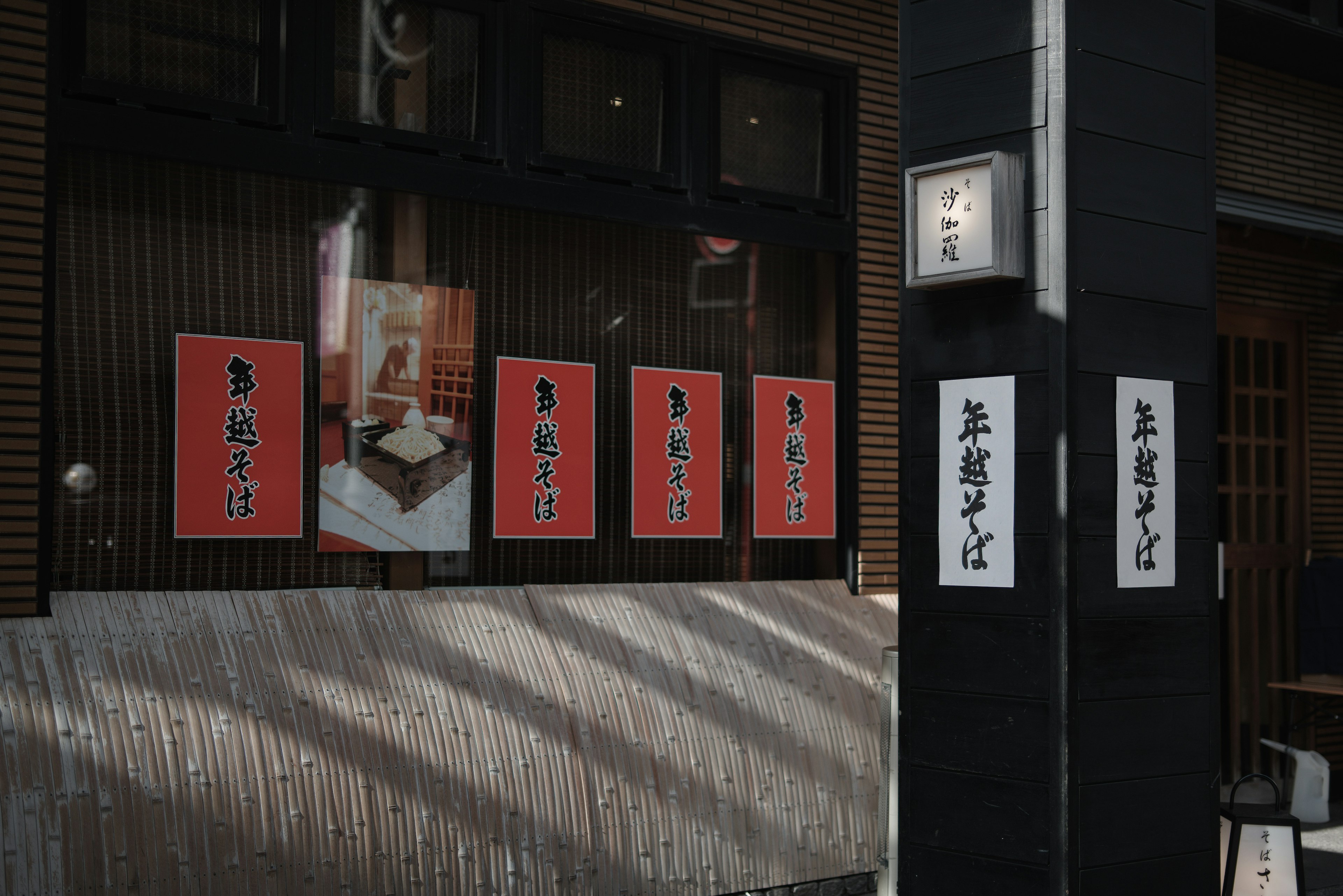 Extérieur d'un restaurant japonais avec des affiches rouges