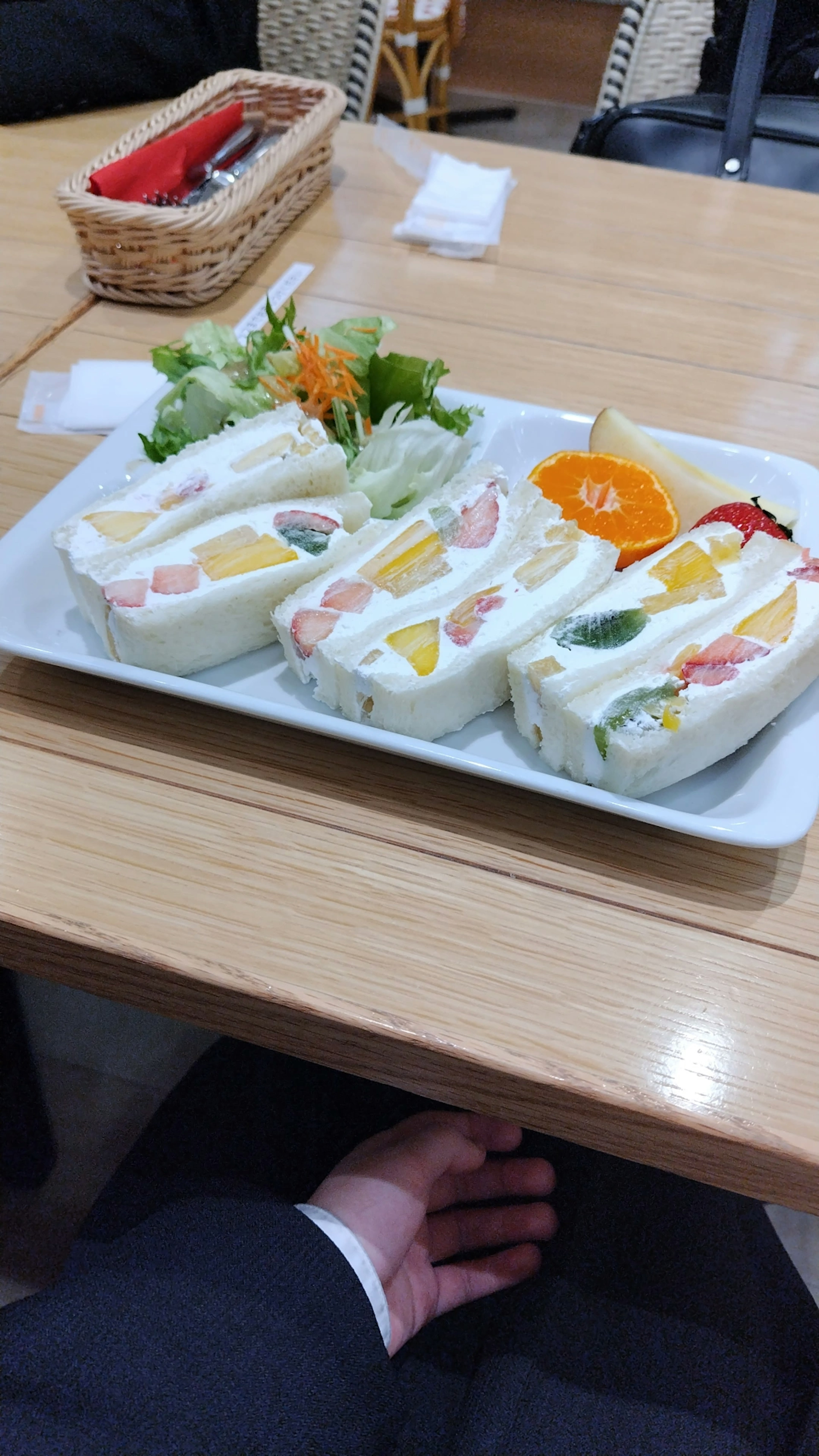 Plato de sándwiches de frutas coloridas con ensalada y rodajas de naranja