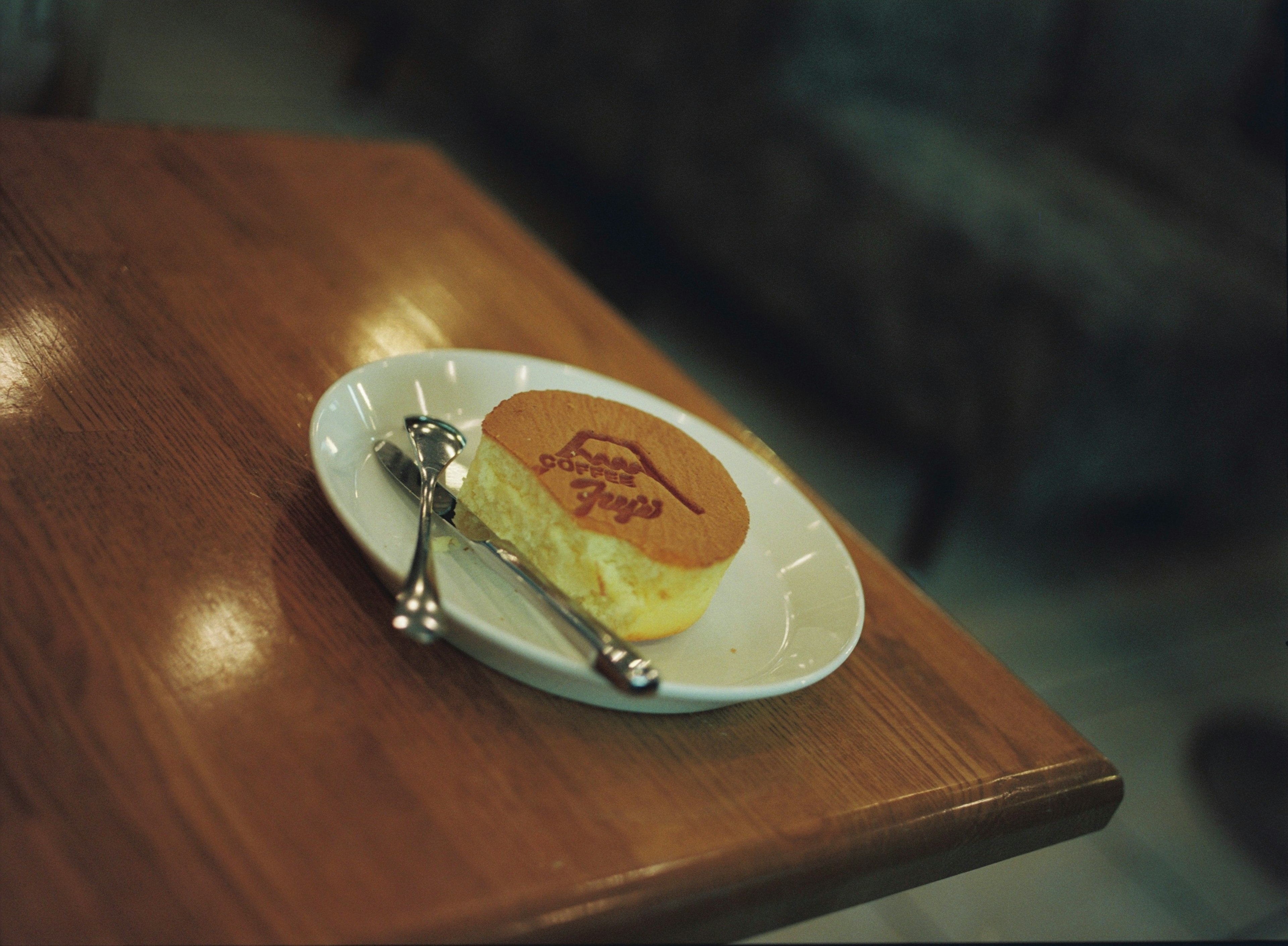 An elegantly designed cake on a wooden table with a spoon