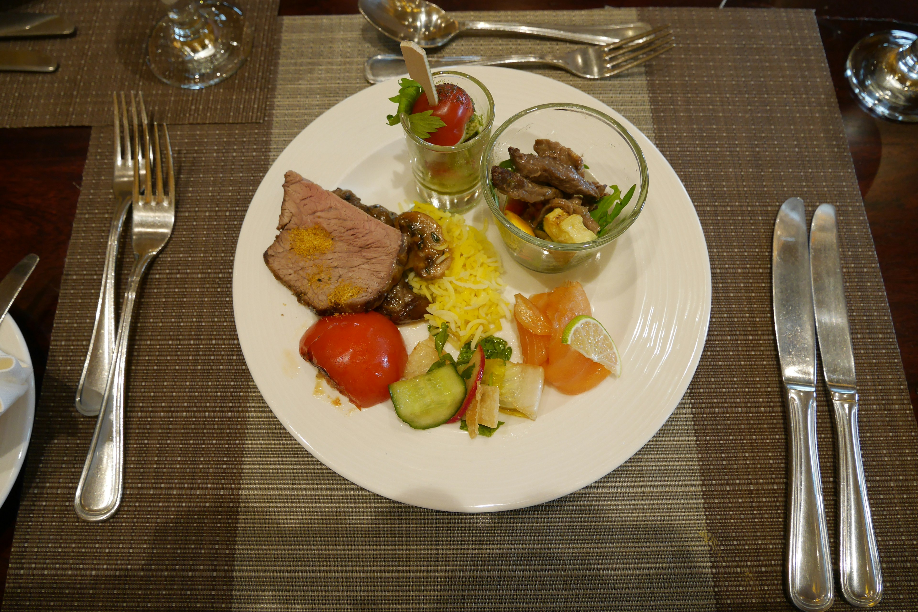 A beautifully arranged plate featuring meat dishes and fresh vegetable salad