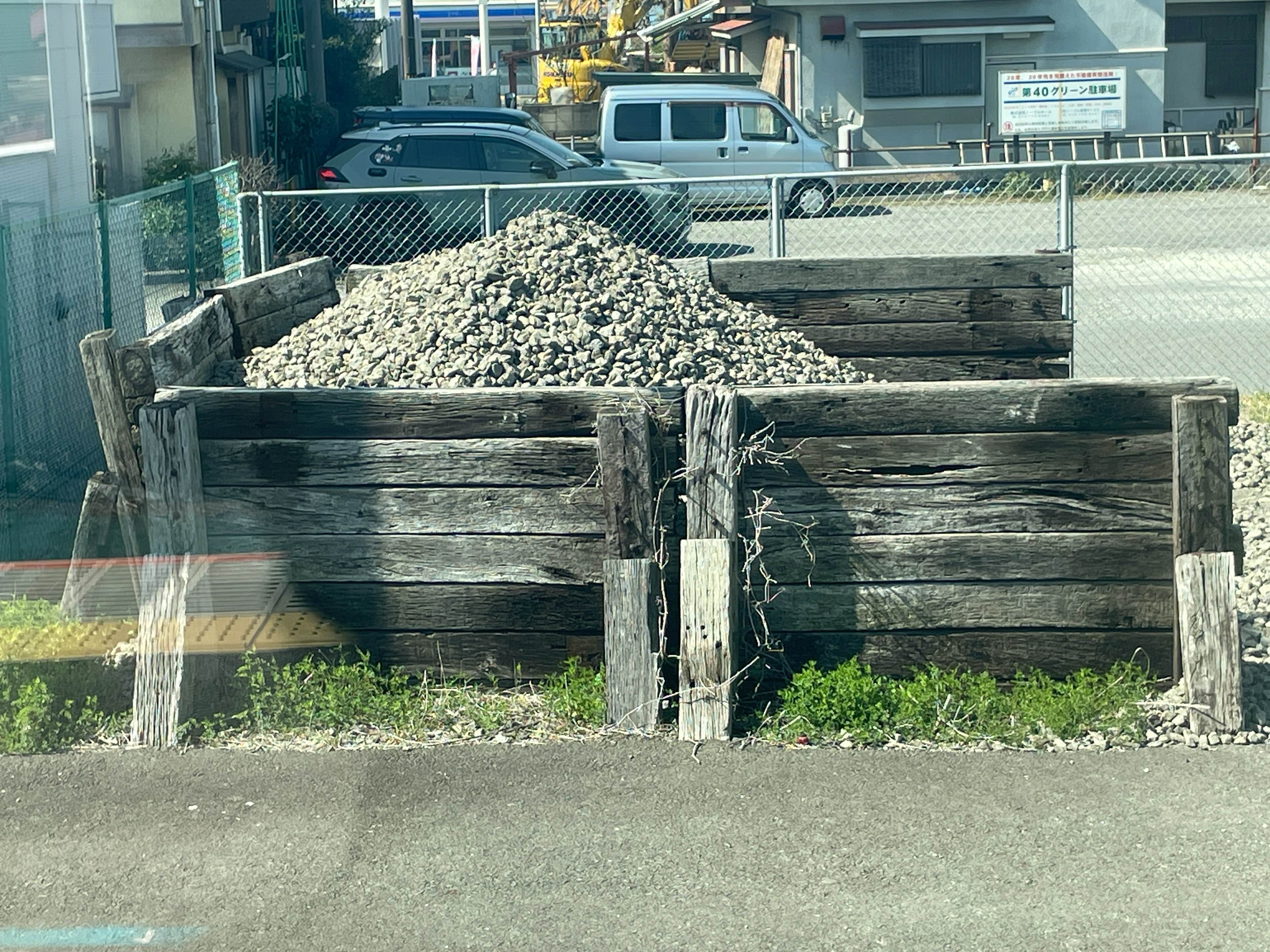 木製の囲いに囲まれた石の山がある風景