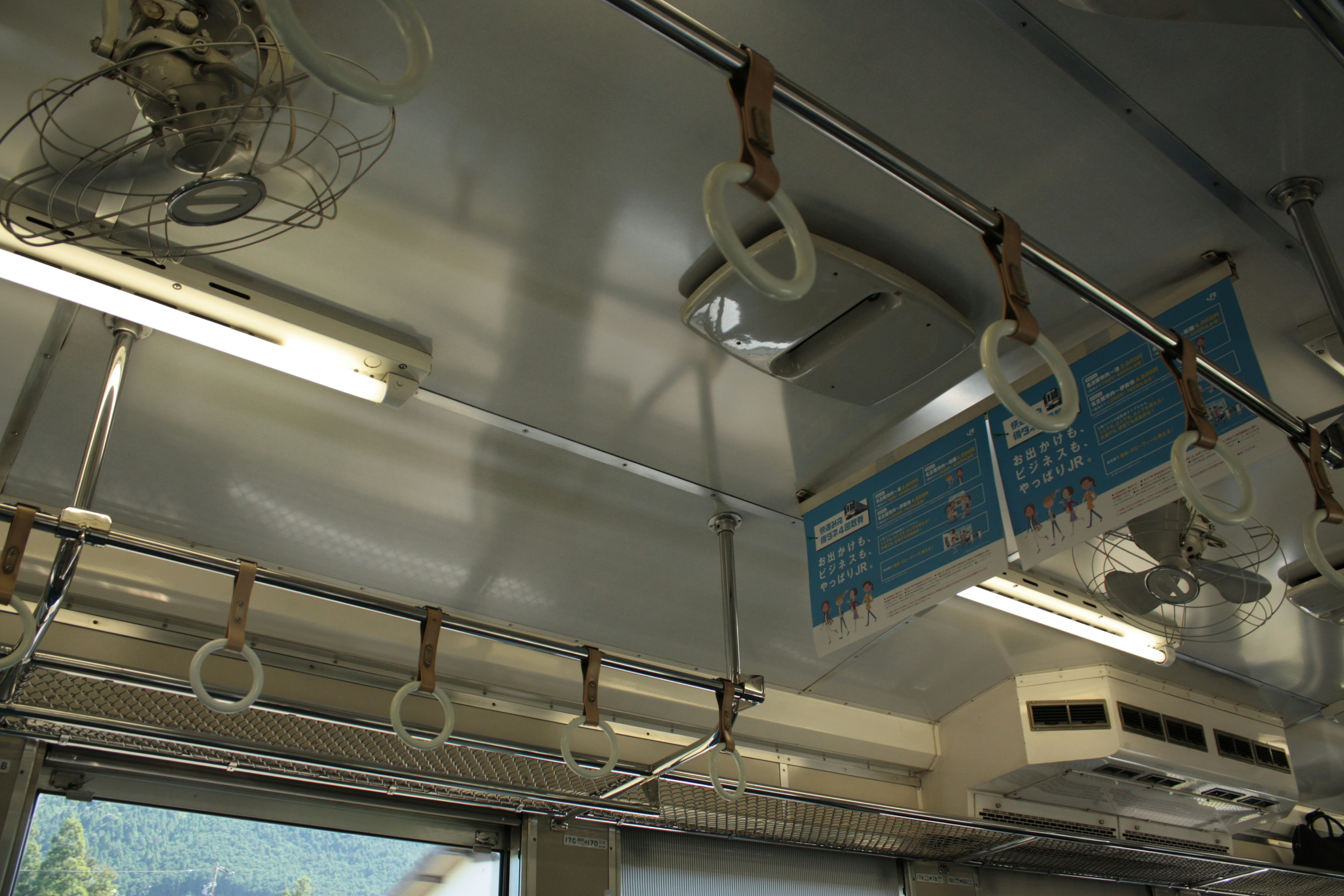 Interior of a train car showing ceiling and grab handles