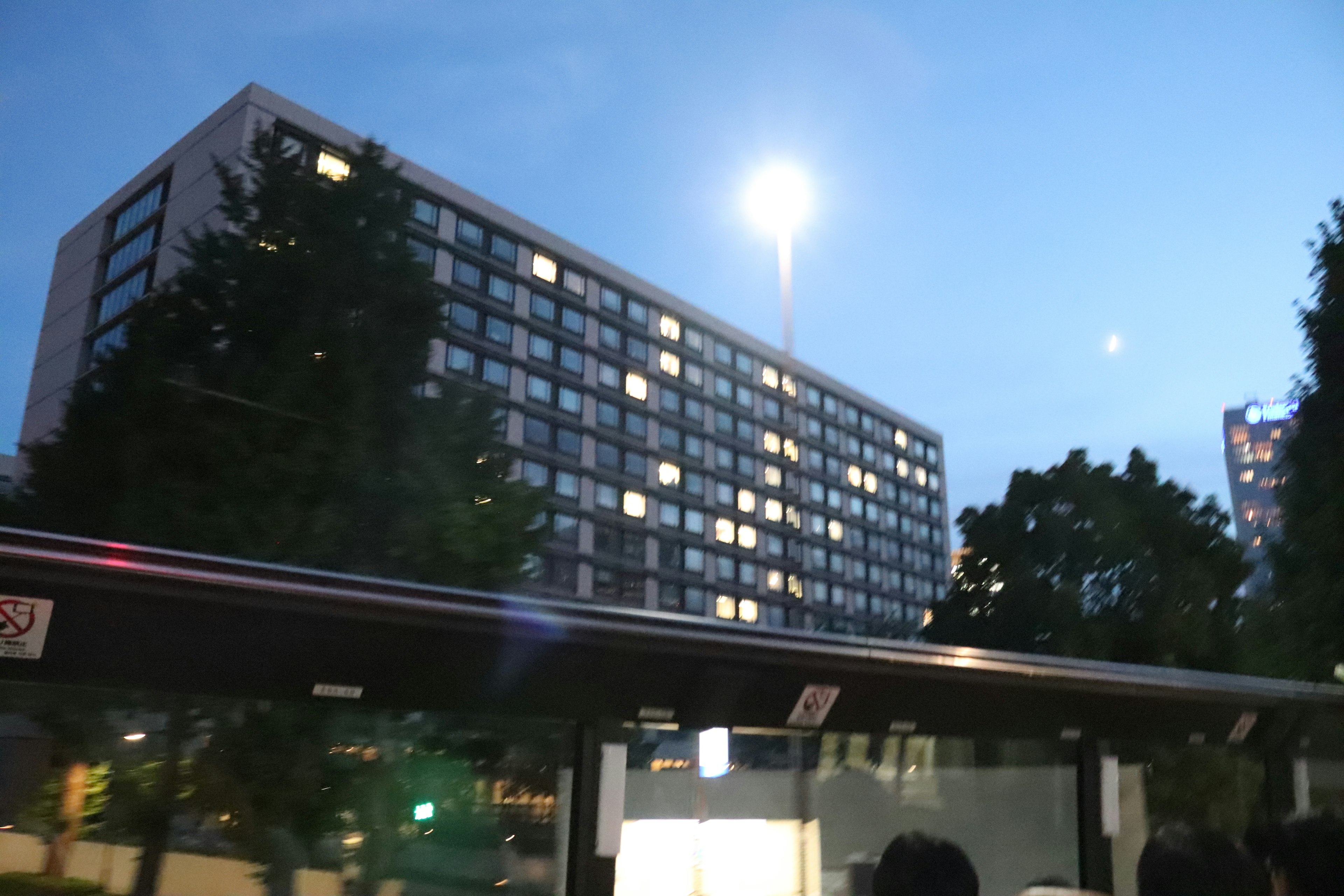 Edificio moderno illuminato di notte con lampione e cielo blu