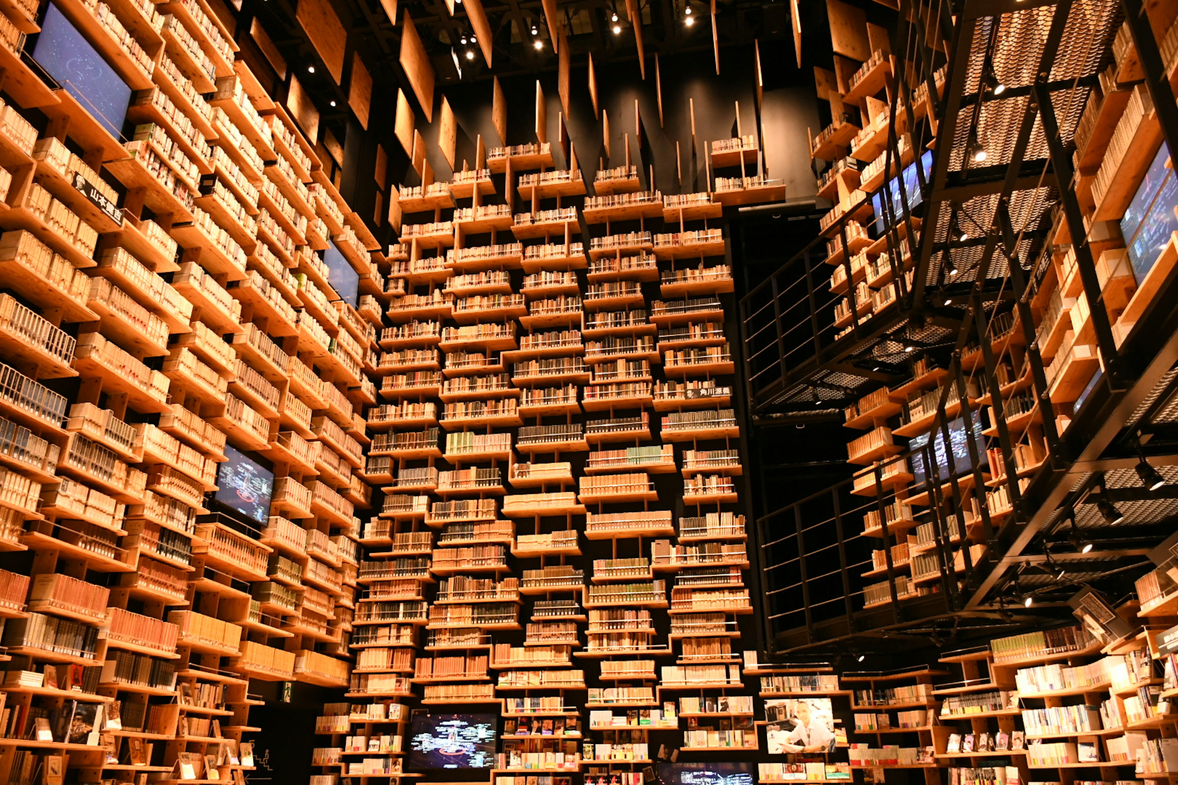 Interior de una biblioteca única con paredes de libros apilados escalera visible