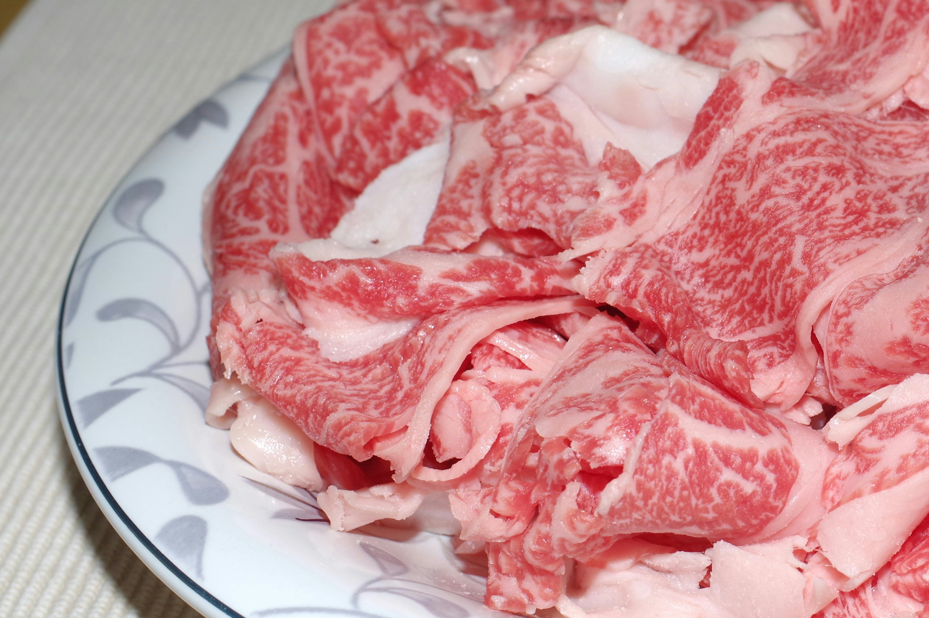 Thinly sliced Wagyu beef with beautiful marbling arranged on a plate