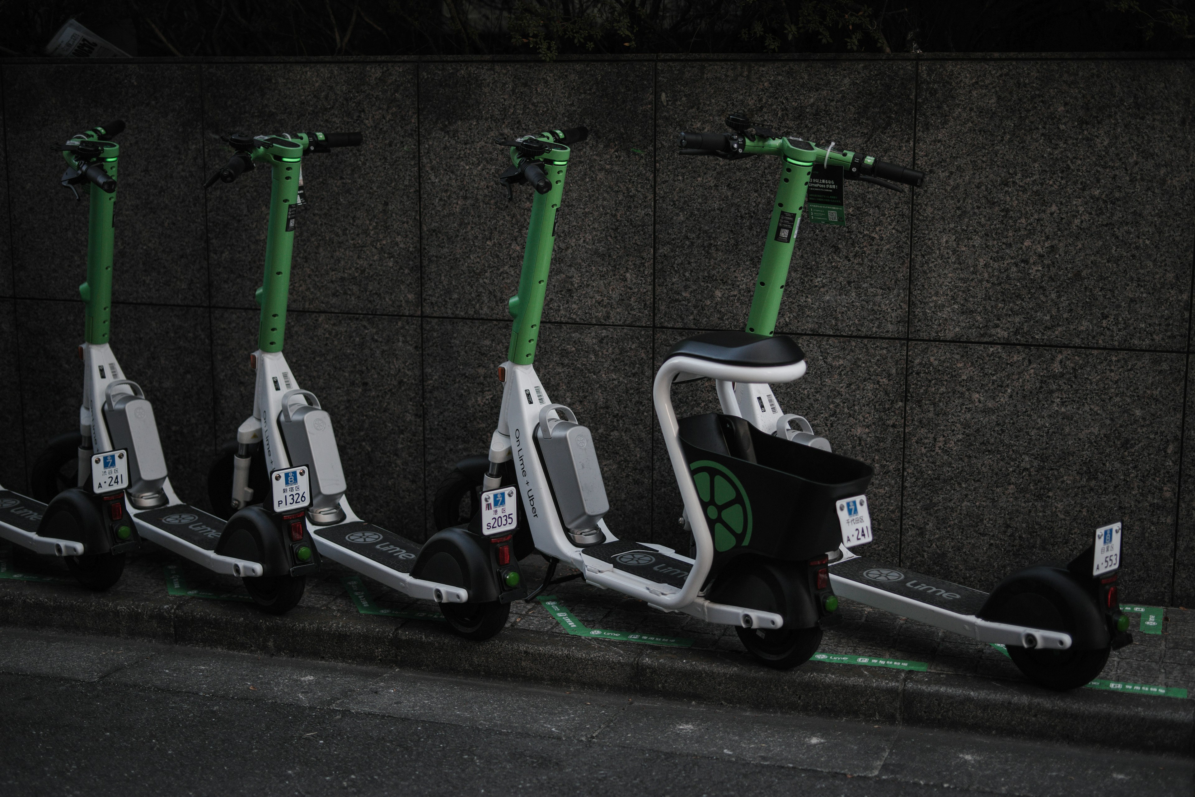 緑色の電動スクーターが並んでいる街角の風景