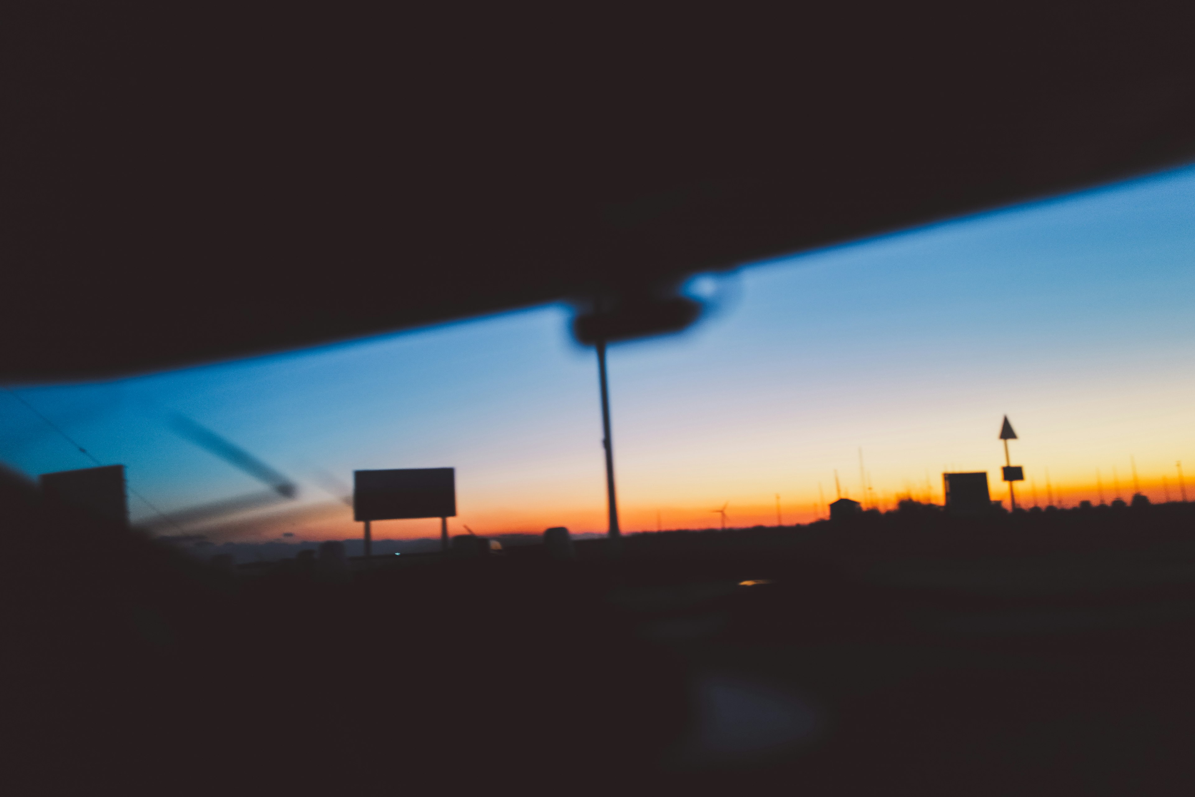 Vista attraverso un finestrino dell'auto che mostra un tramonto vibrante