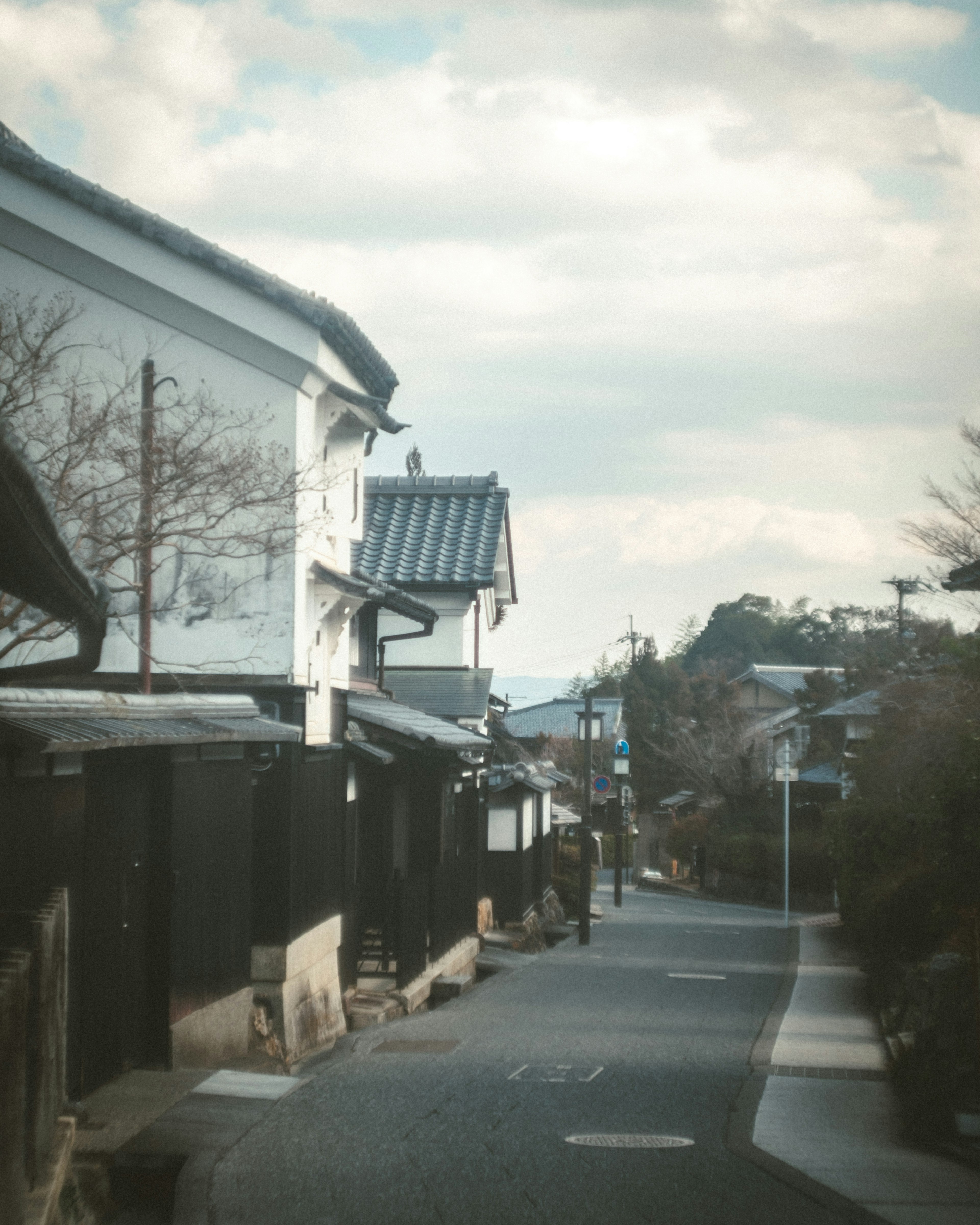 Ruhige Straßenszene mit traditionellen japanischen Häusern und bewölktem Himmel