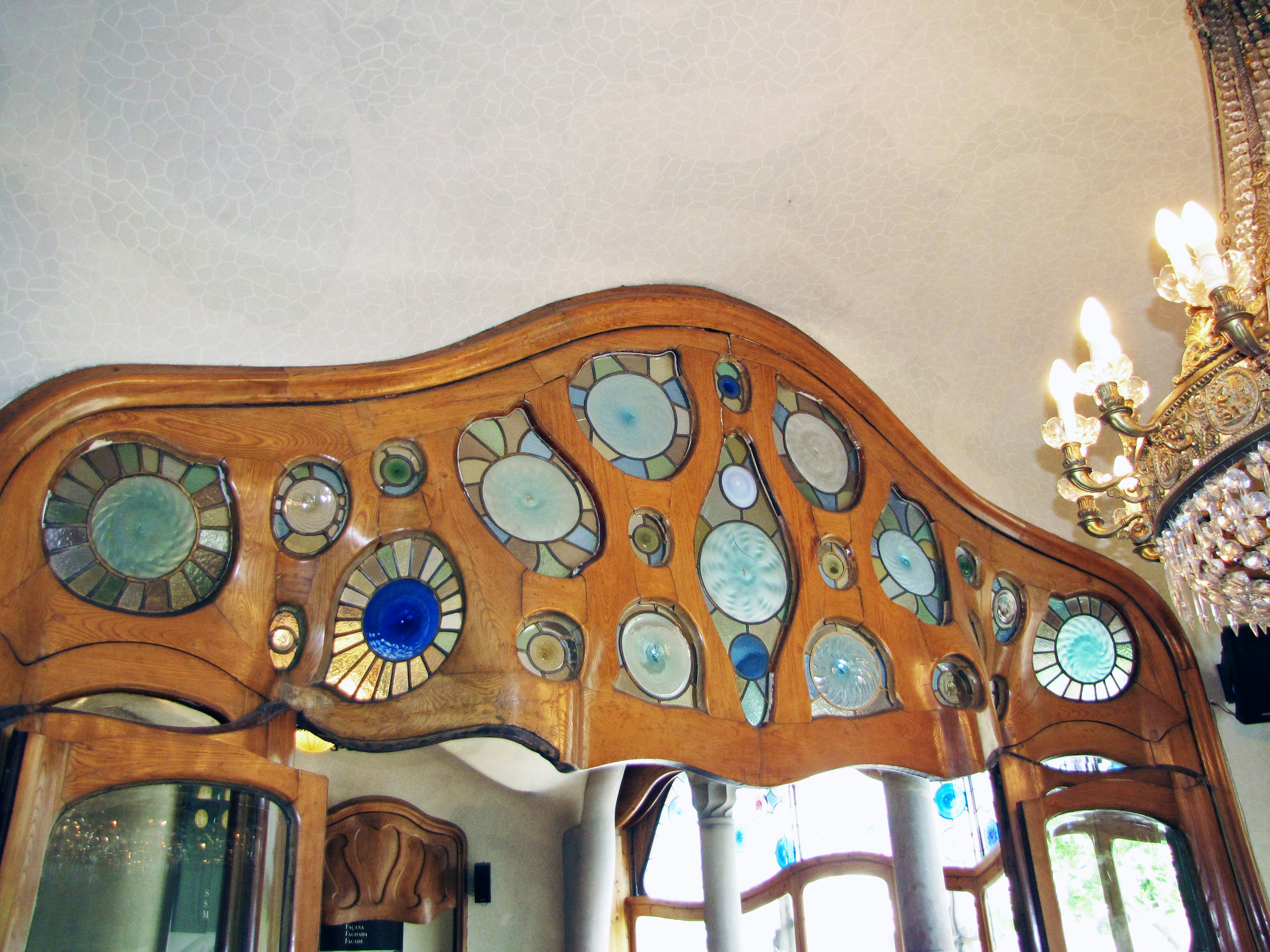 Decorative mirror frame designed by Antoni Gaudí featuring various shapes and colors