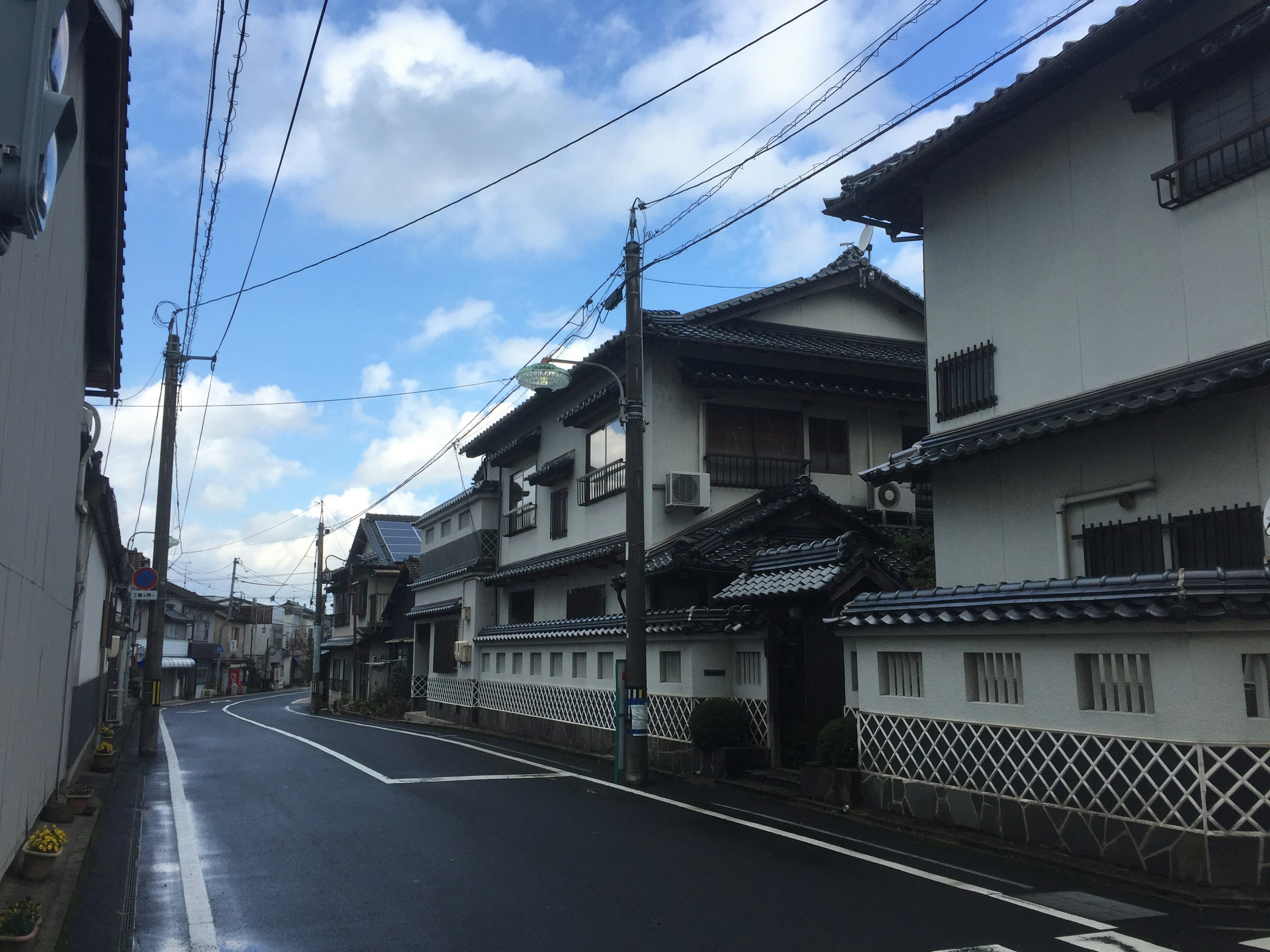 Ruhige Straßenszene in Japan mit traditionellen Häusern und blauem Himmel