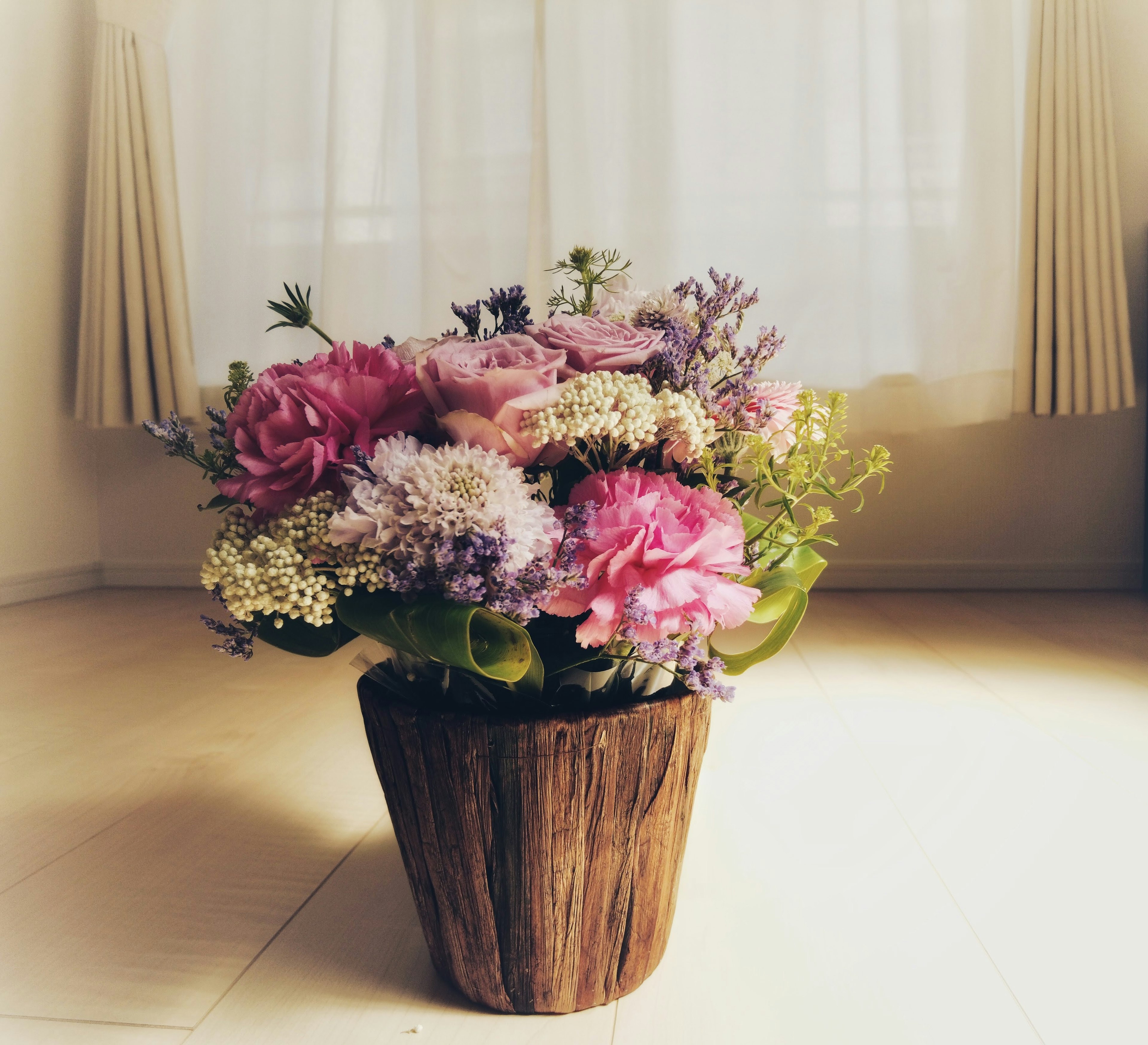 Un bellissimo mazzo di fiori in un vaso di legno