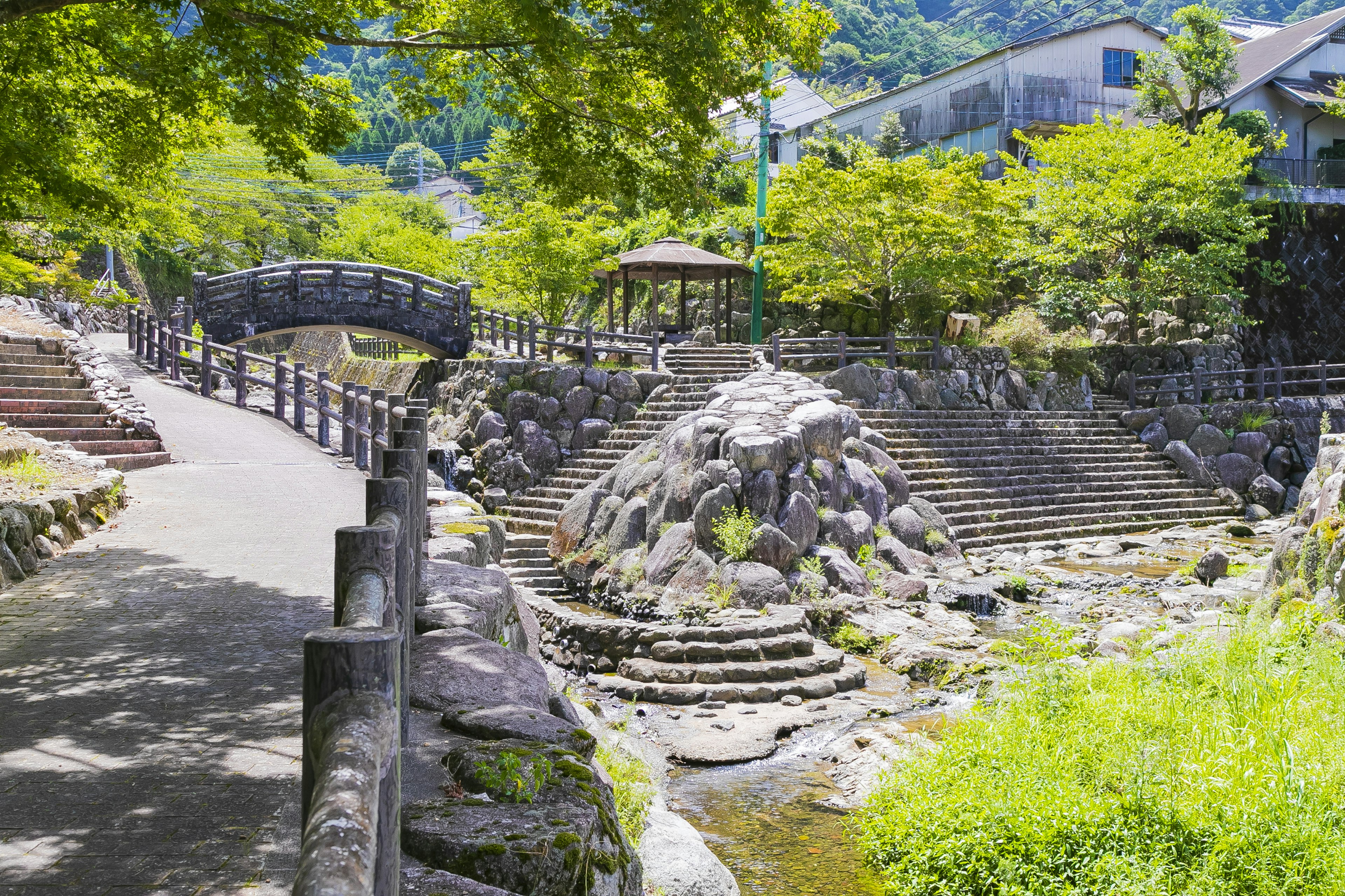 Paisaje de jardín pintoresco con un puente y escaleras de piedra rodeadas de vegetación