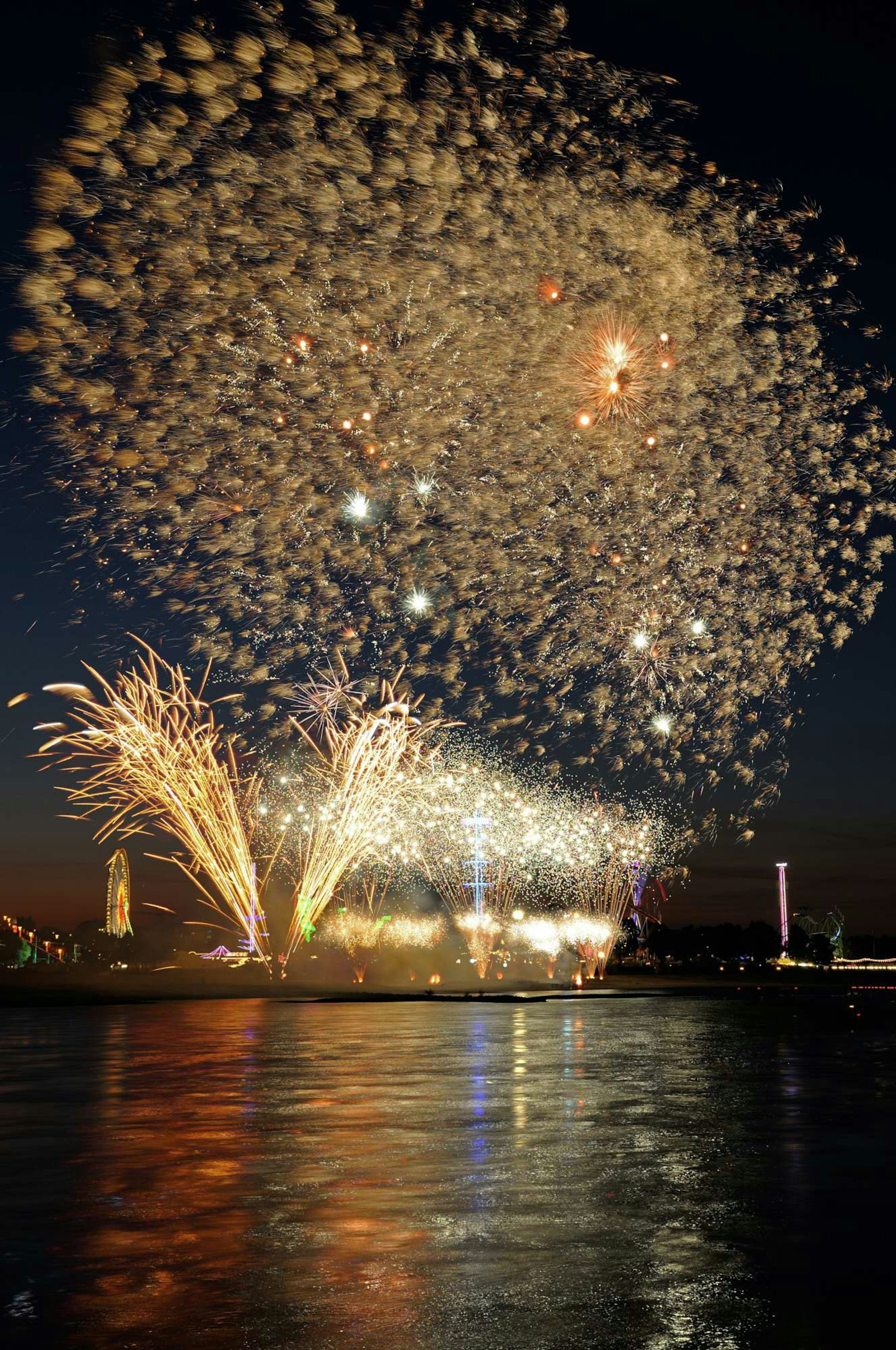 Fireworks display illuminating the night sky reflections on the water