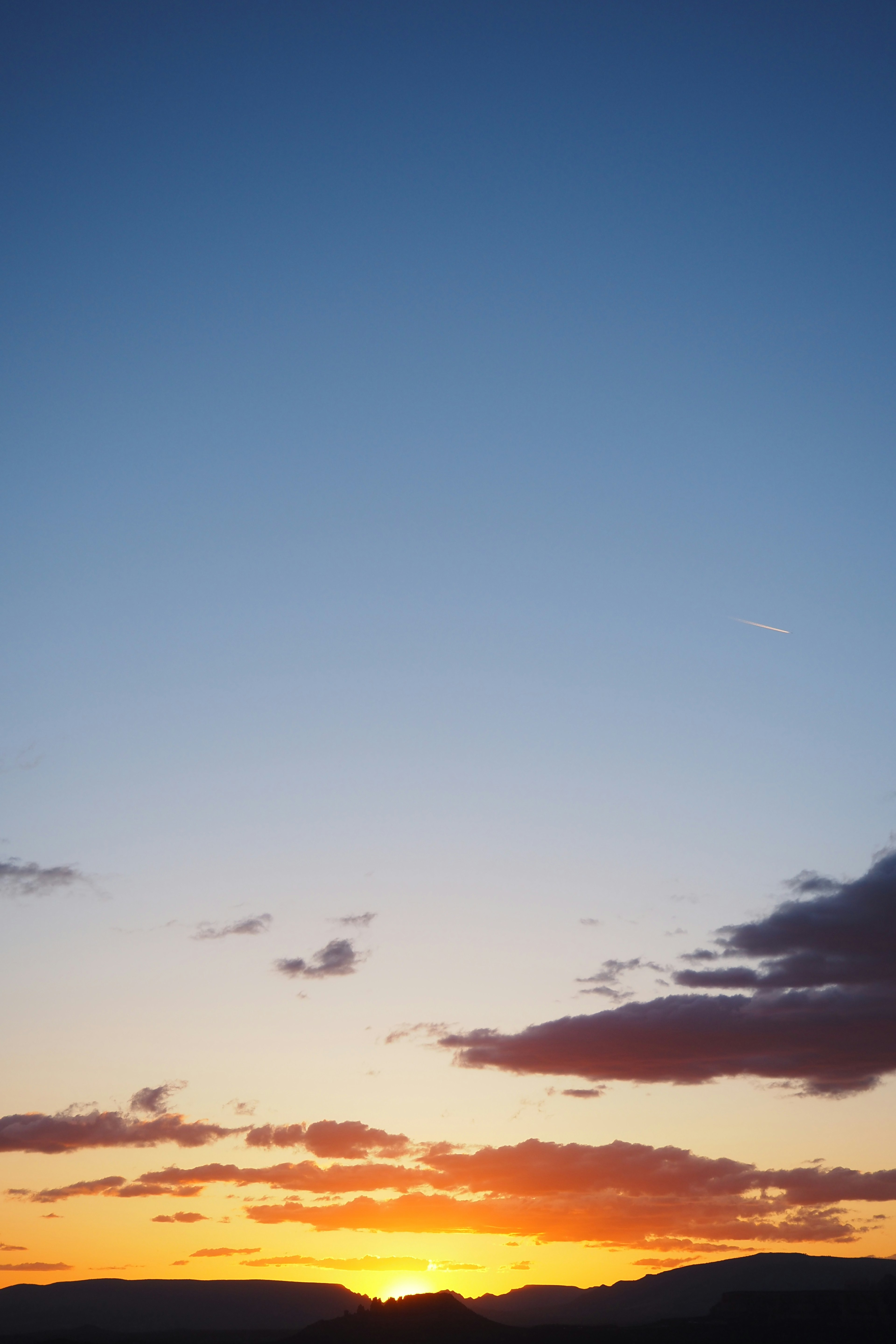 Lebendiger Sonnenuntergang mit orangefarbenen Tönen vor blauem Himmel