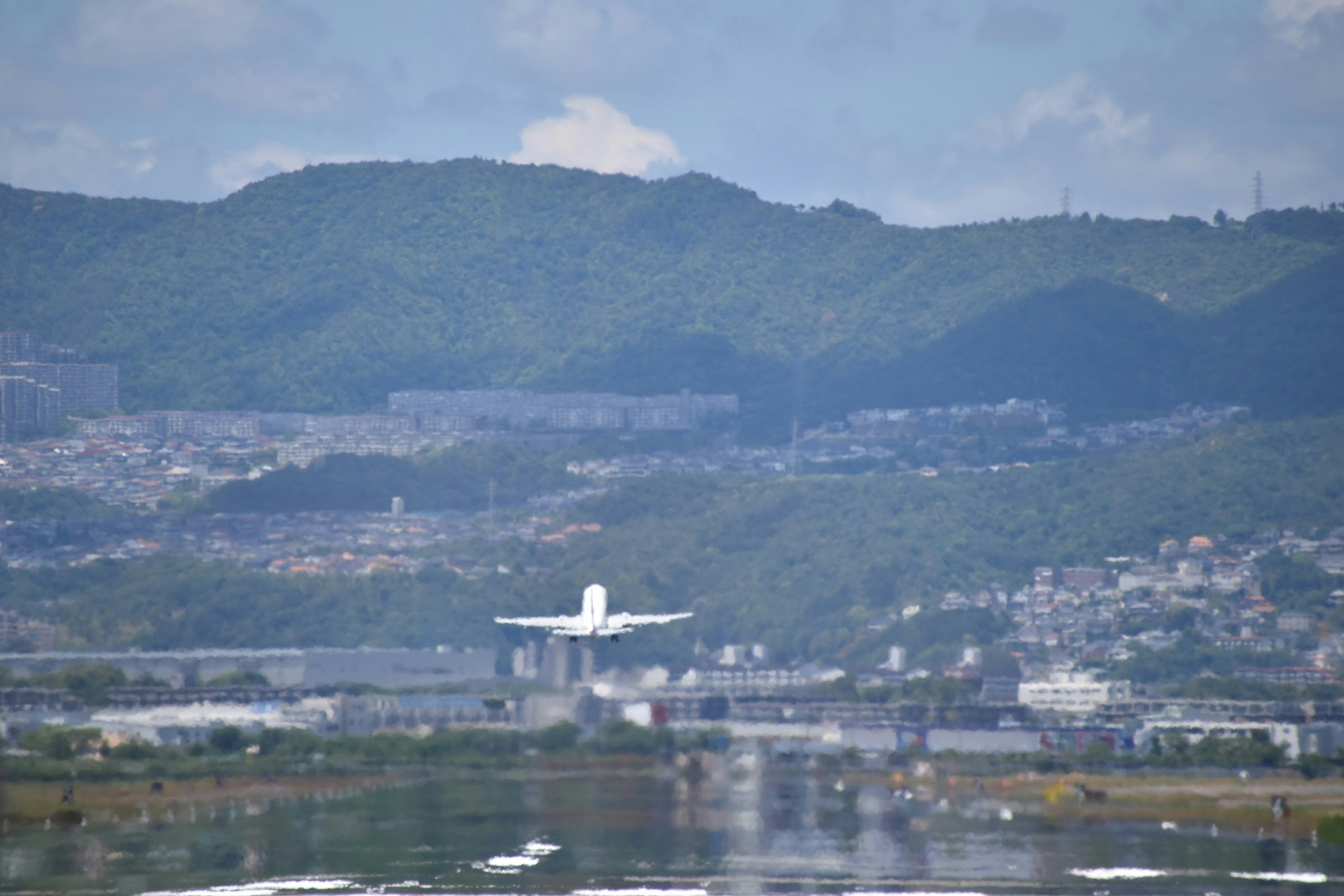 山々を背景に着陸する飛行機の画像