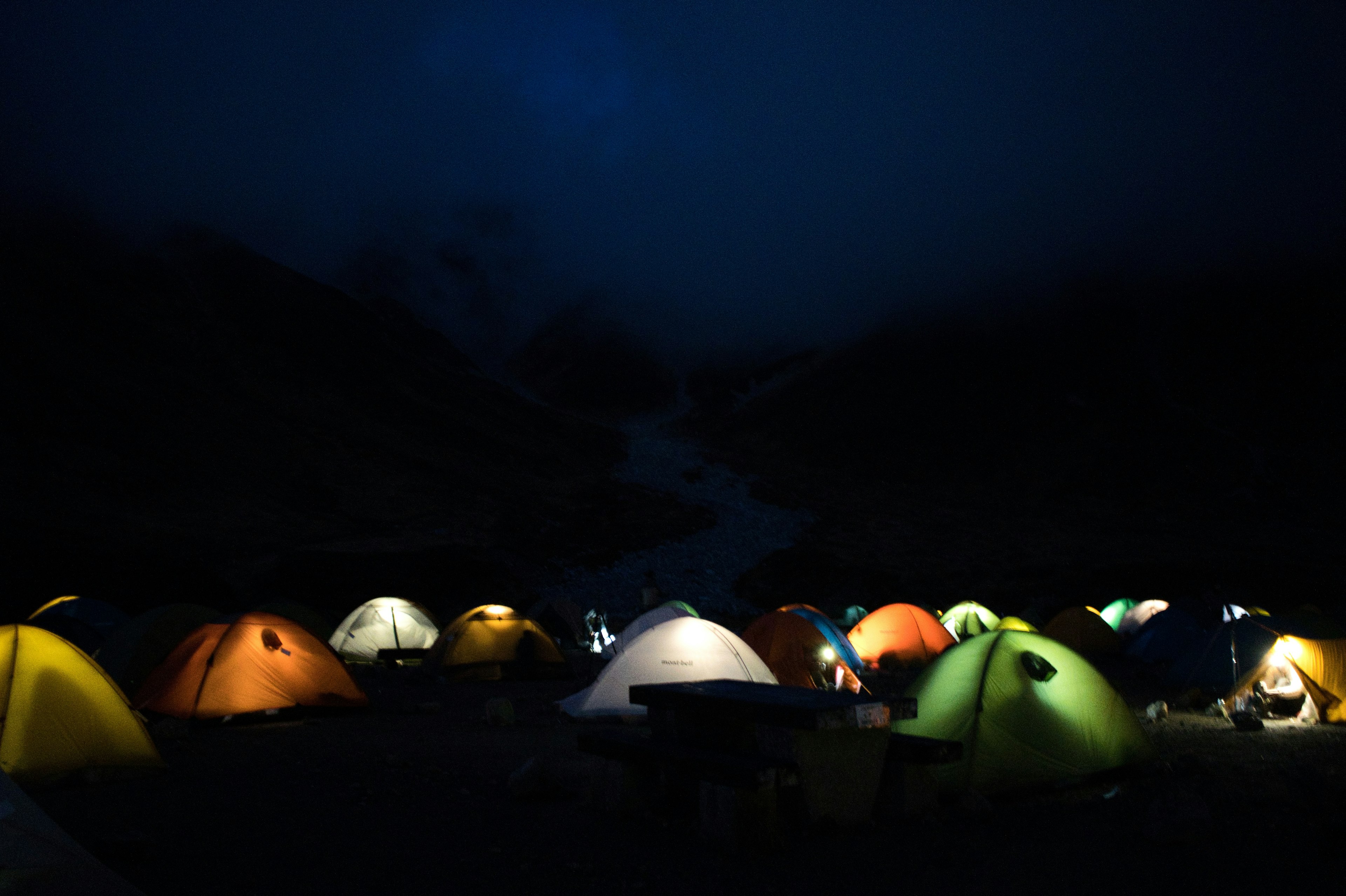 Tentes colorées alignées dans un camping nocturne