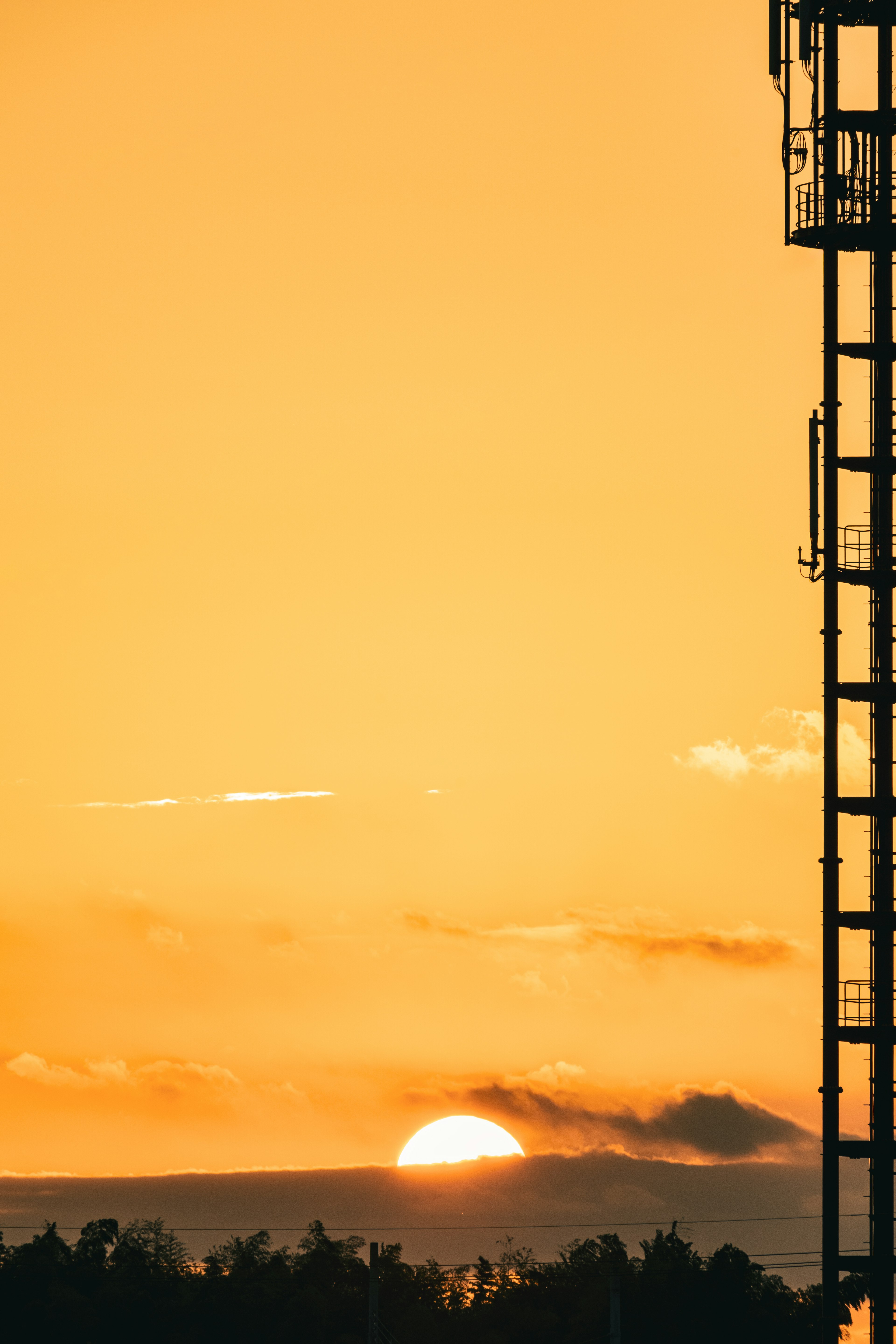 Amanecer sobre el horizonte con la silueta de una torre