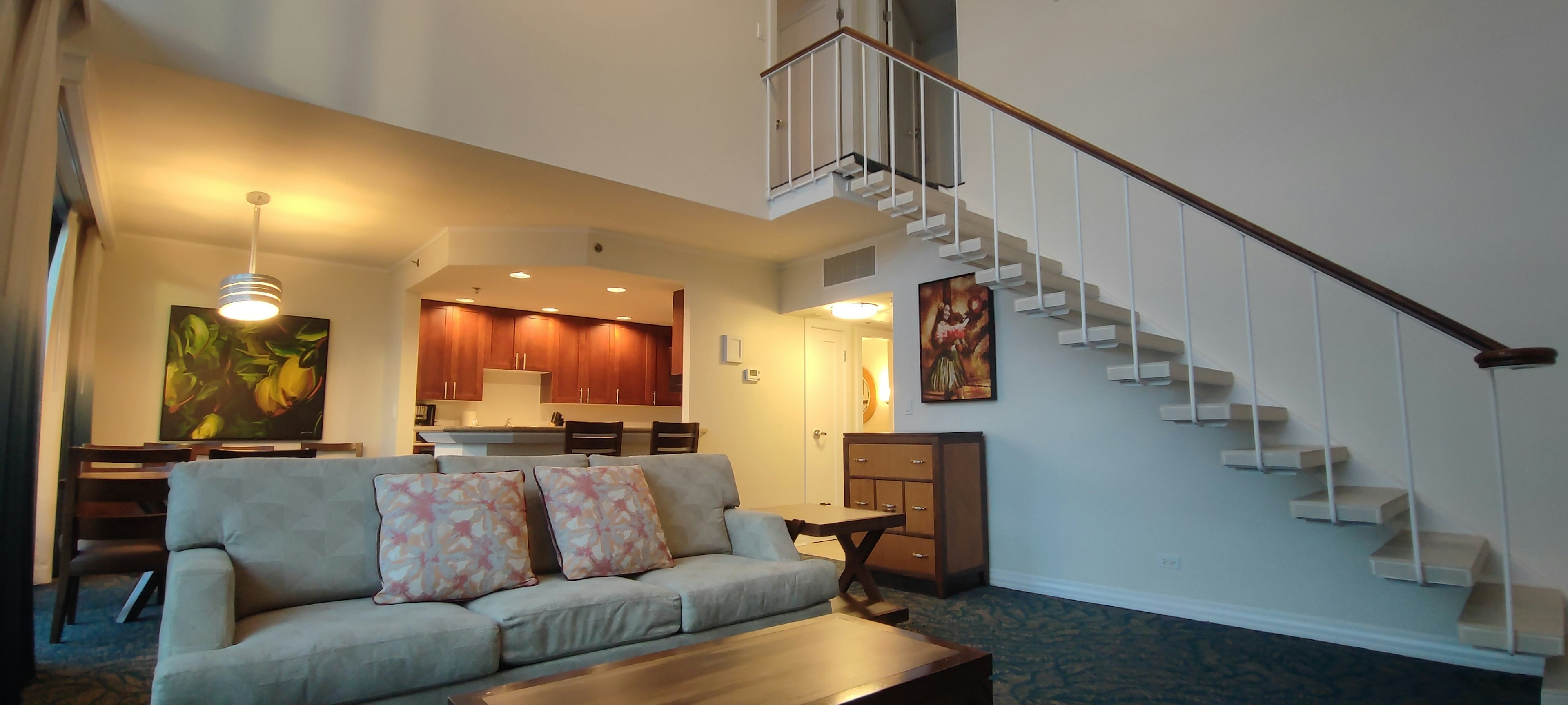 Bright living room featuring a sofa and a staircase with simple decor