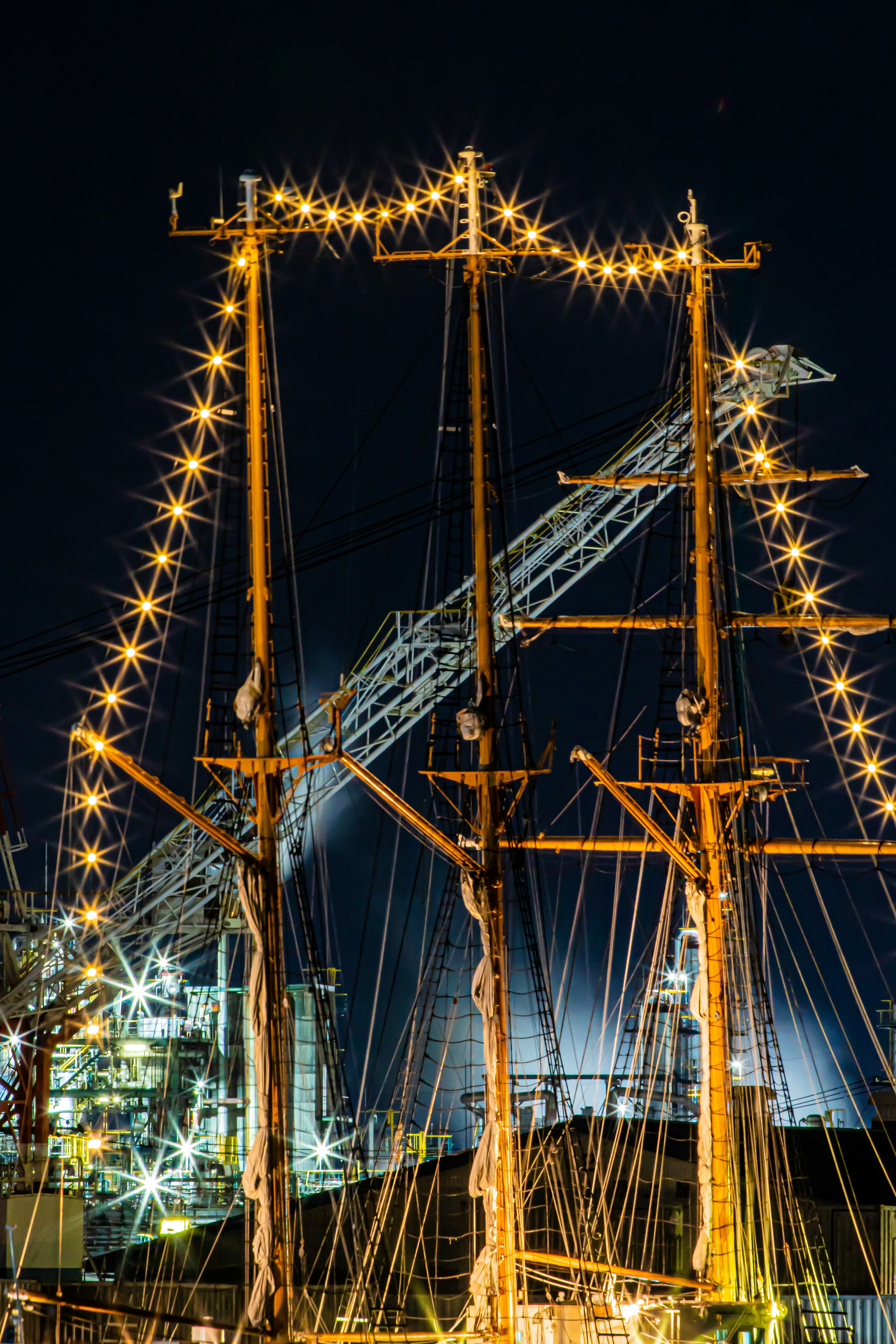 Affichage lumineux brillant sur les mâts d'un bateau la nuit dans le port