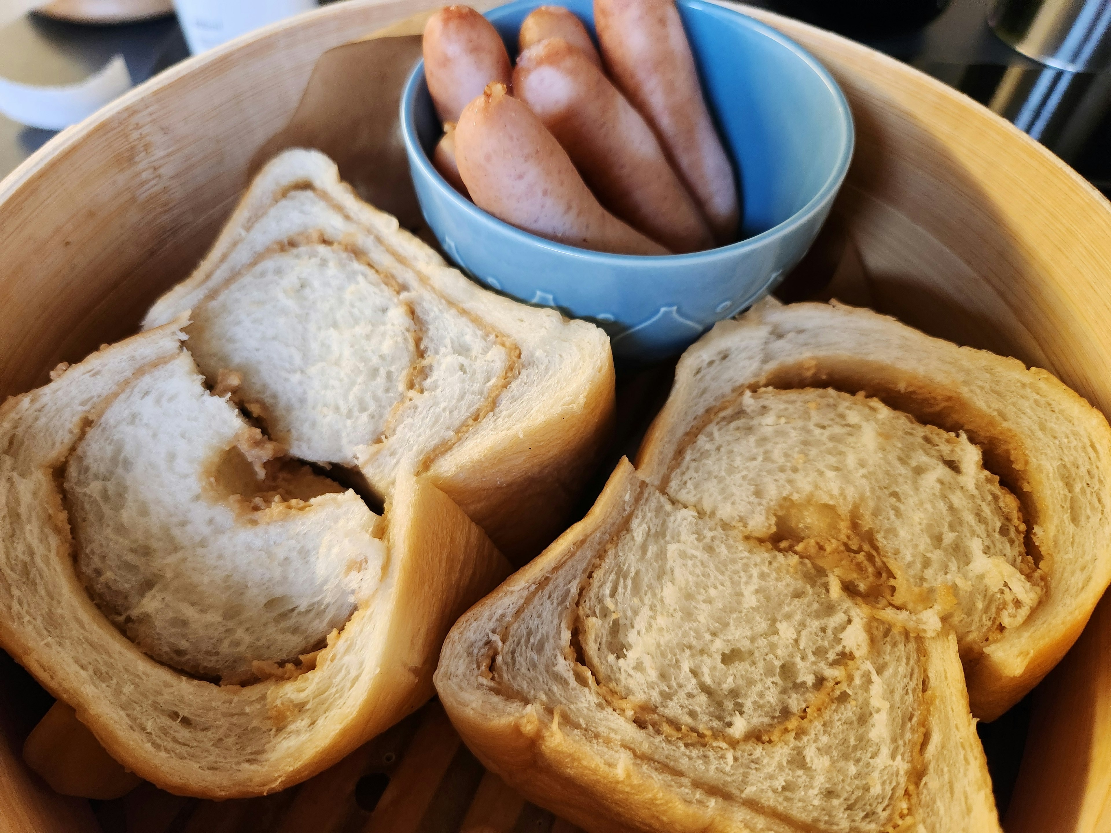 찜통에 있는 식빵 조각과 파란 그릇에 담긴 소시지