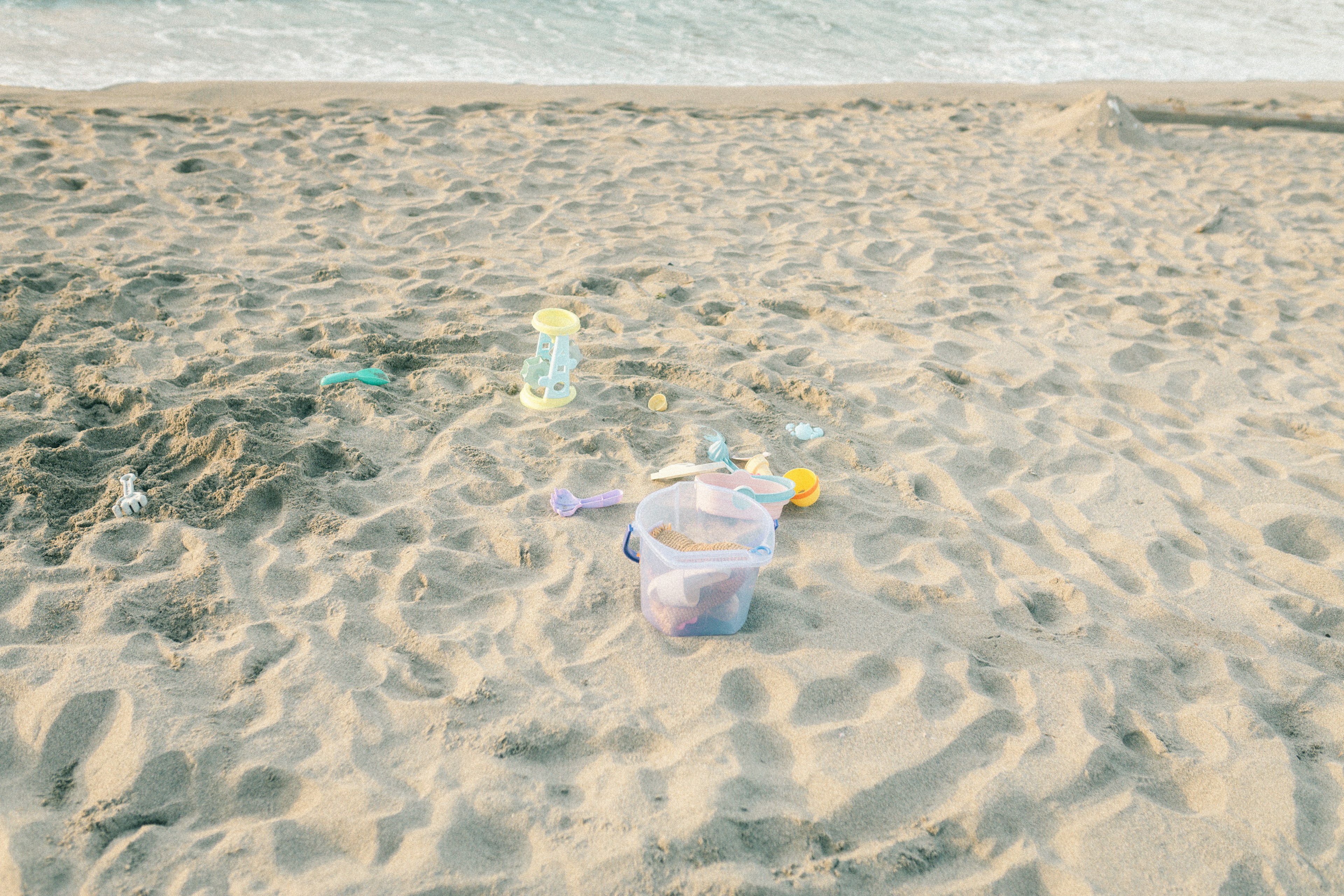 Beach scene with scattered toys and buckets