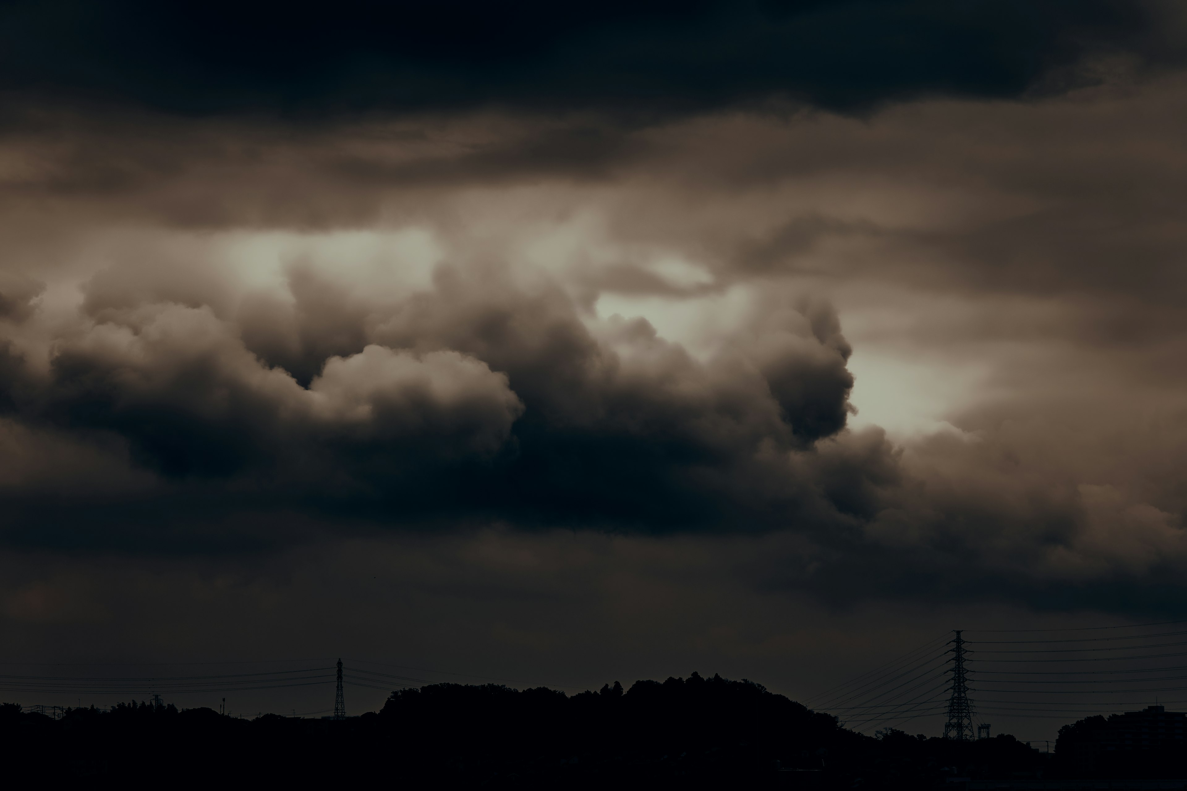 Nuages sombres remplissant le ciel avec des collines en silhouette