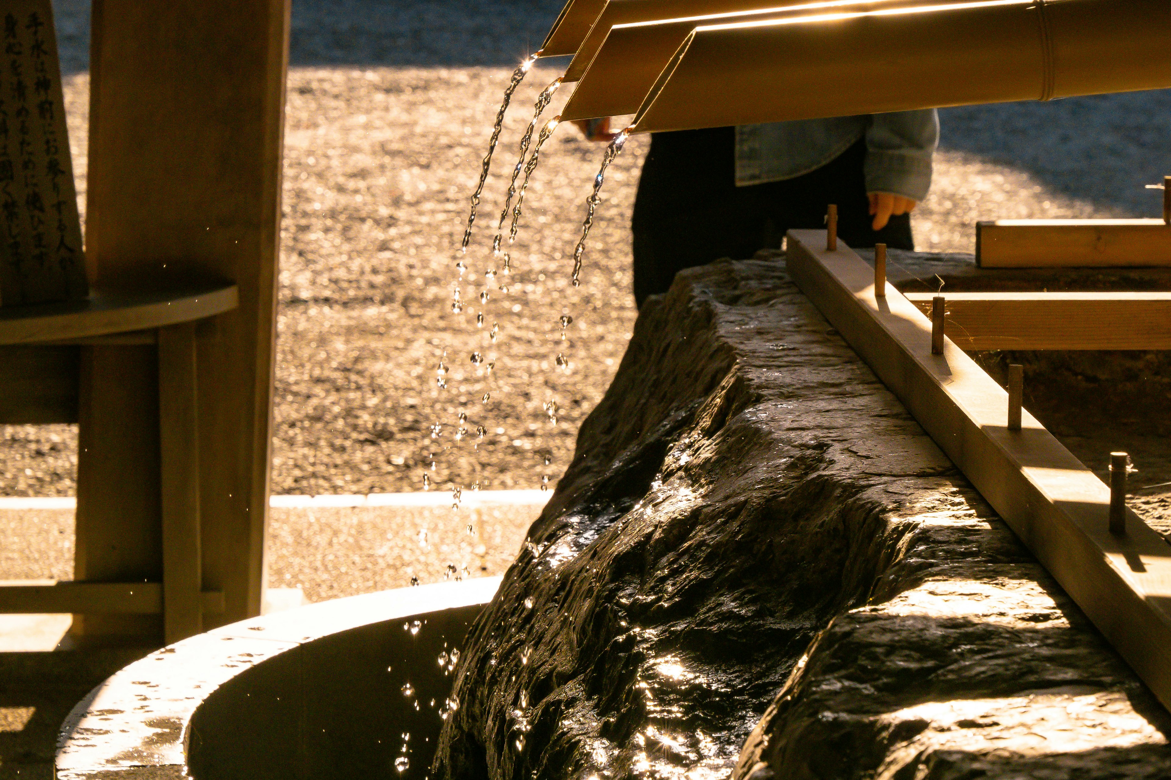 Landscape with flowing water over a rock and wooden structure