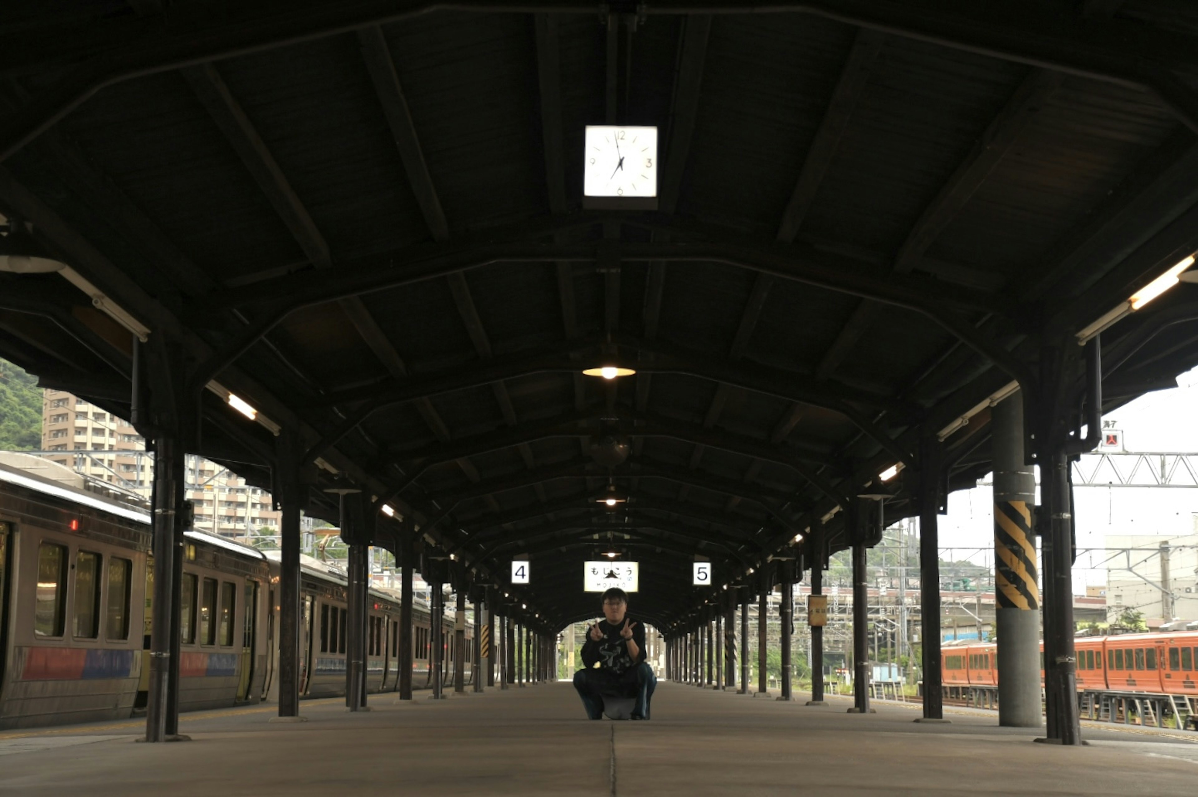 Persona sentada en una plataforma de tren con estructura circundante