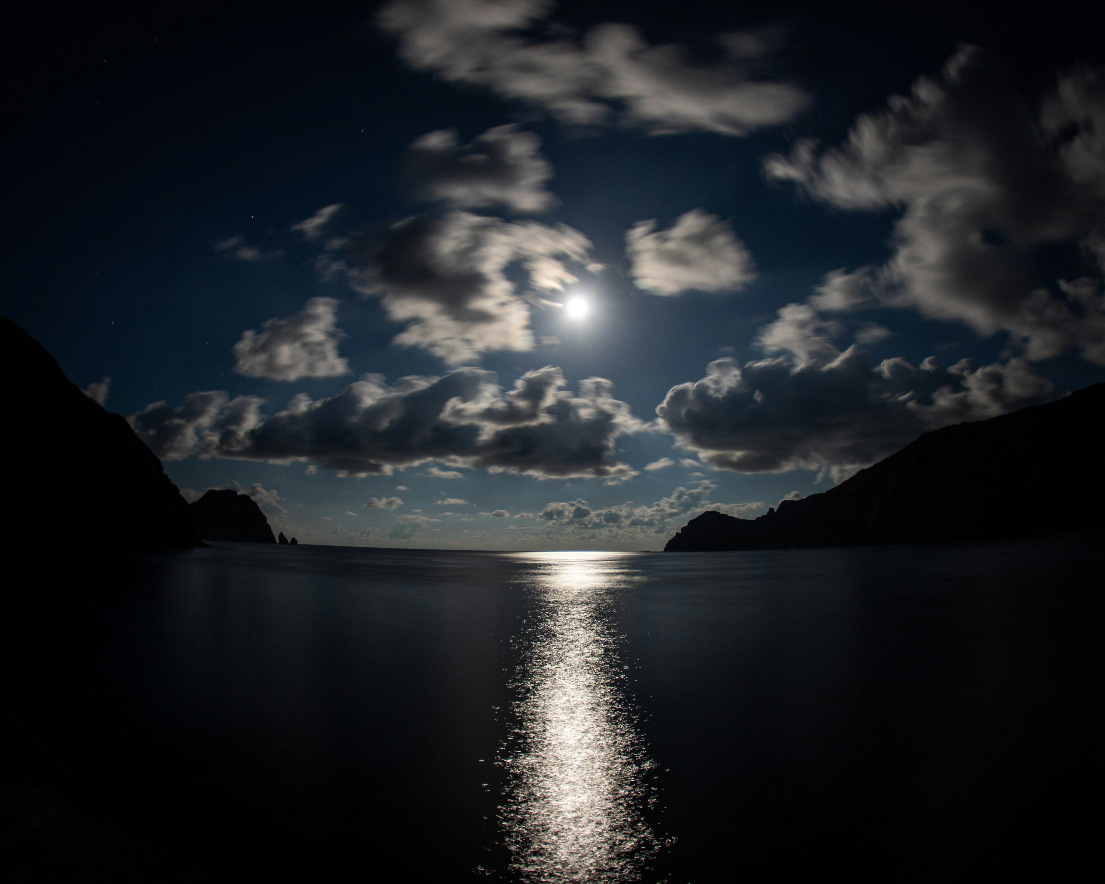 Ruhige Meereslandschaft beleuchtet von Mondlicht und Wolken