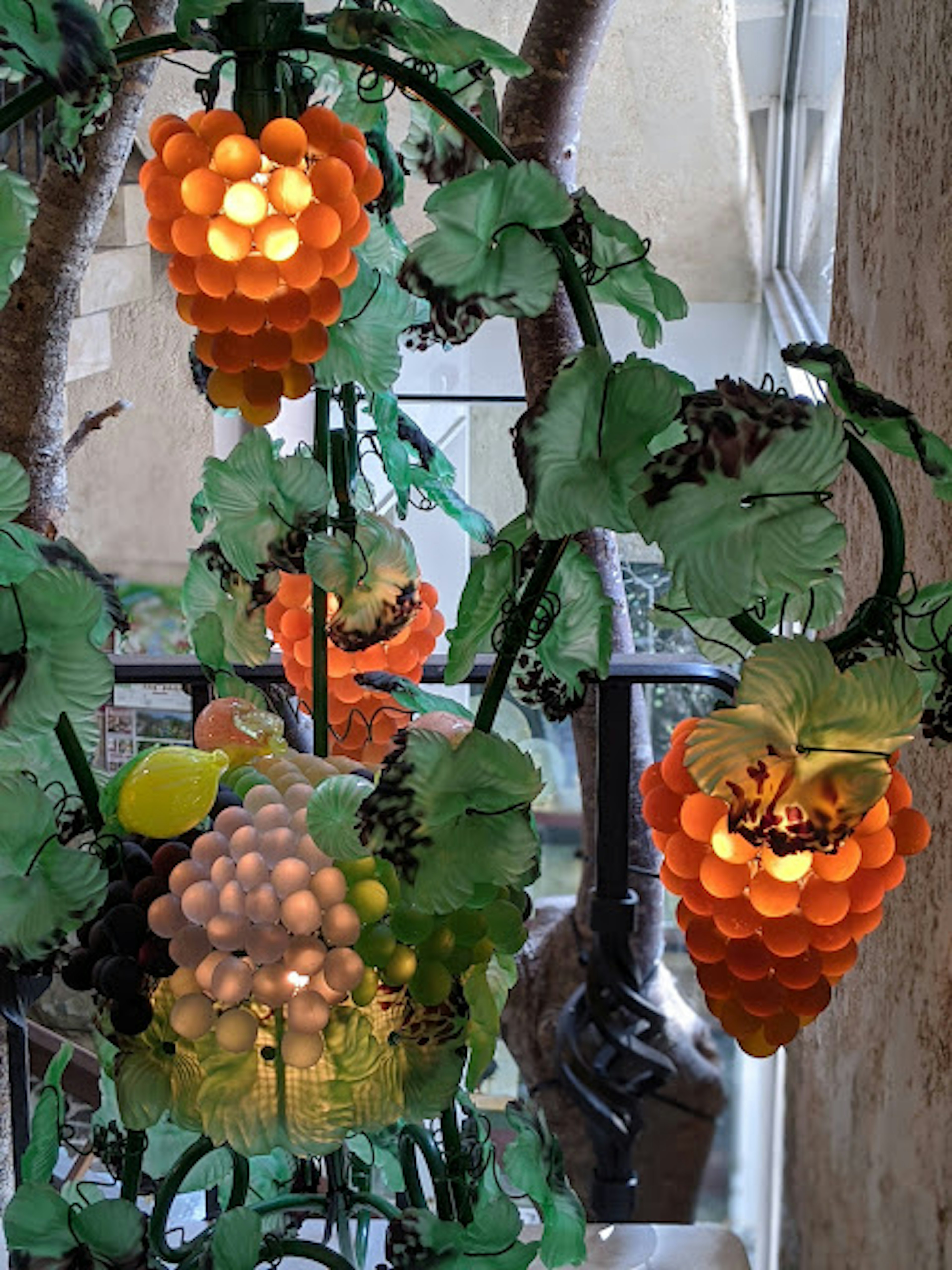 Decorative orange grape-shaped lamps surrounded by green leaves