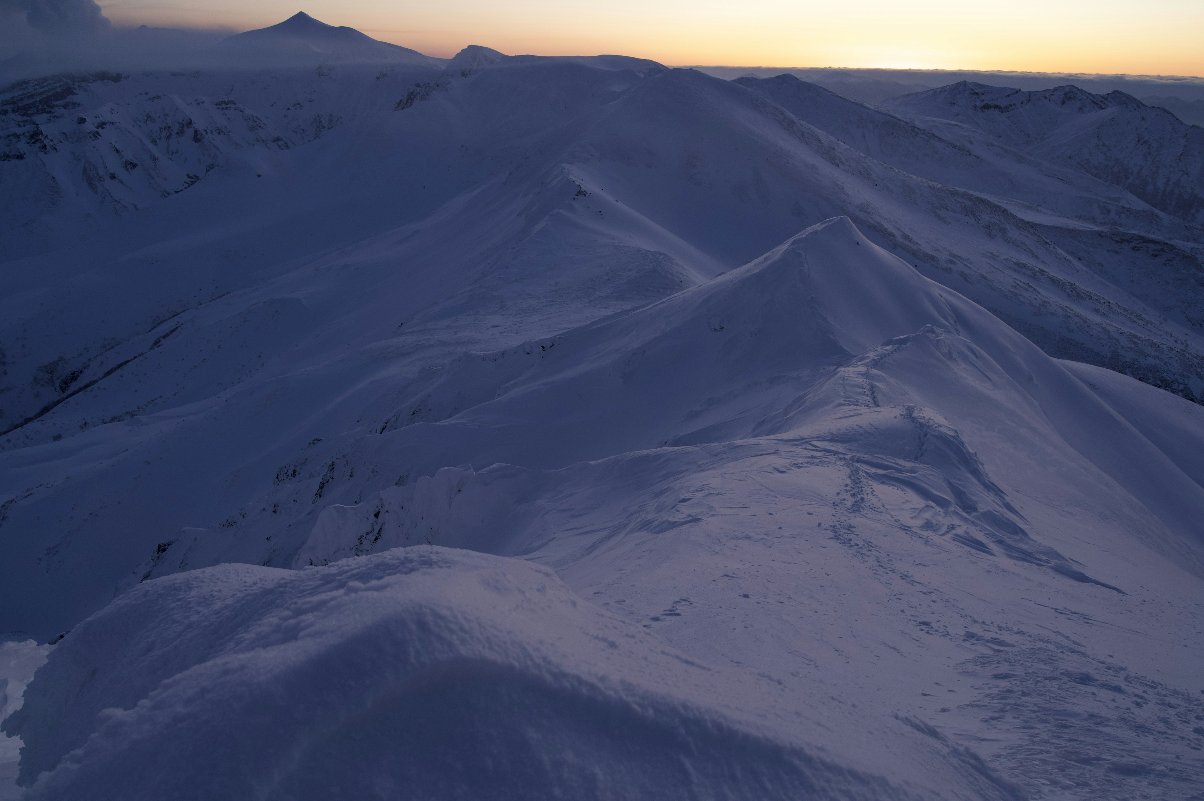 Vista expansiva de montañas cubiertas de nieve al atardecer