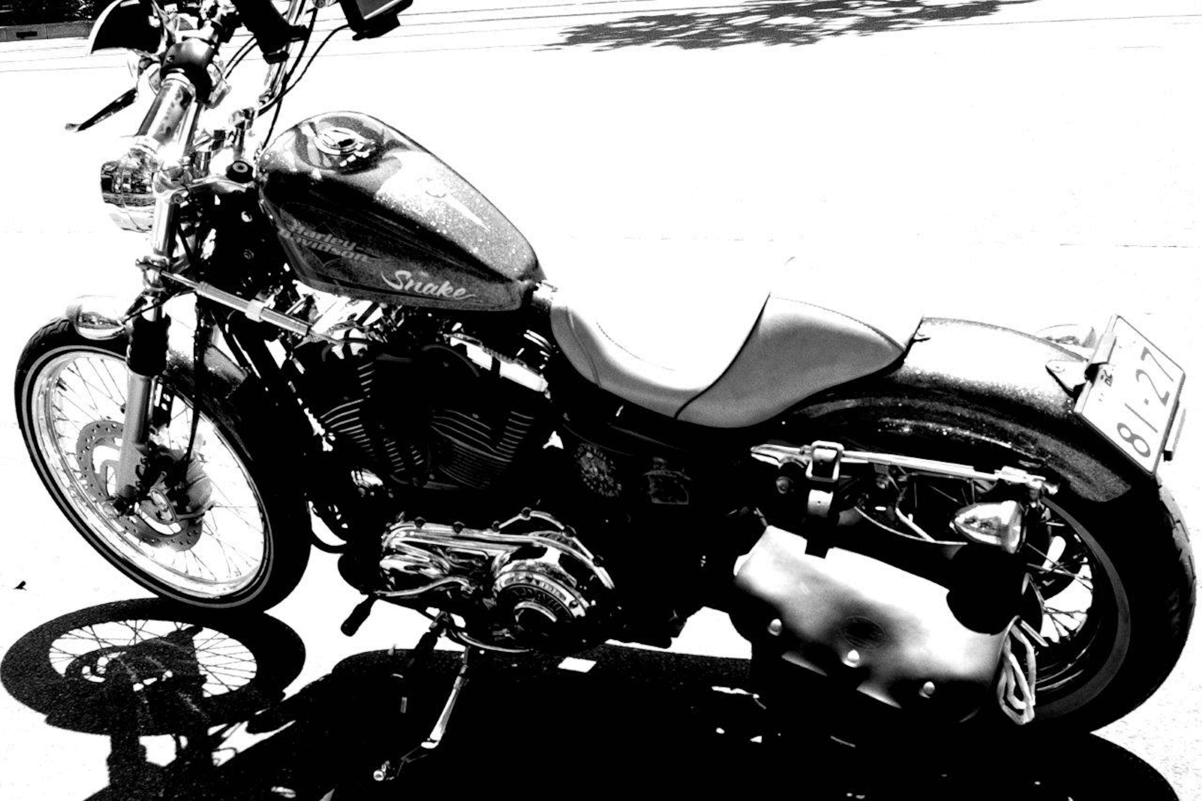 Moto Harley-Davidson en noir et blanc garée dans la rue