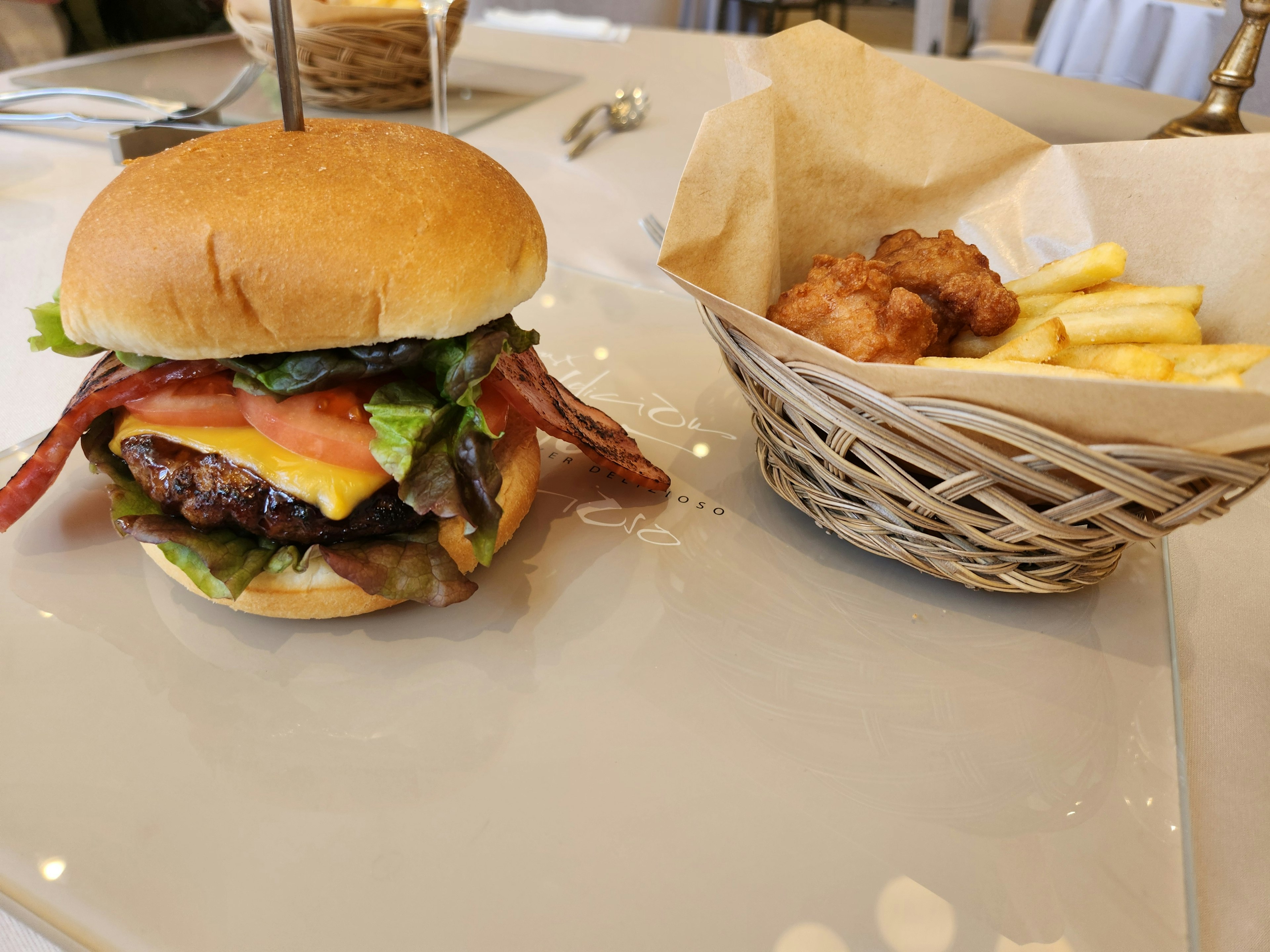 Delizioso hamburger con bacon lattuga pomodoro e patatine in un cestino