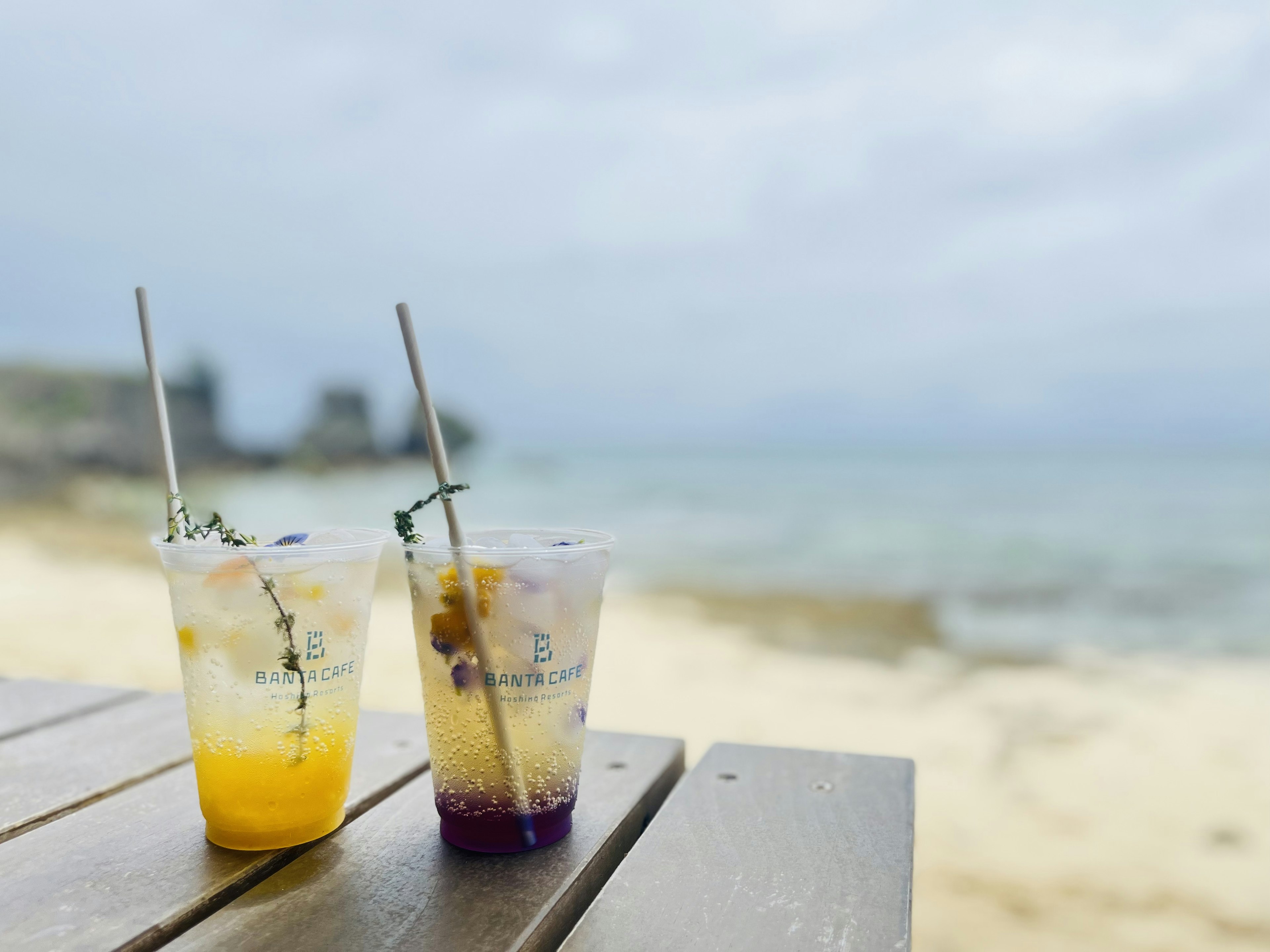 Due cocktail colorati su un tavolo di legno sulla spiaggia