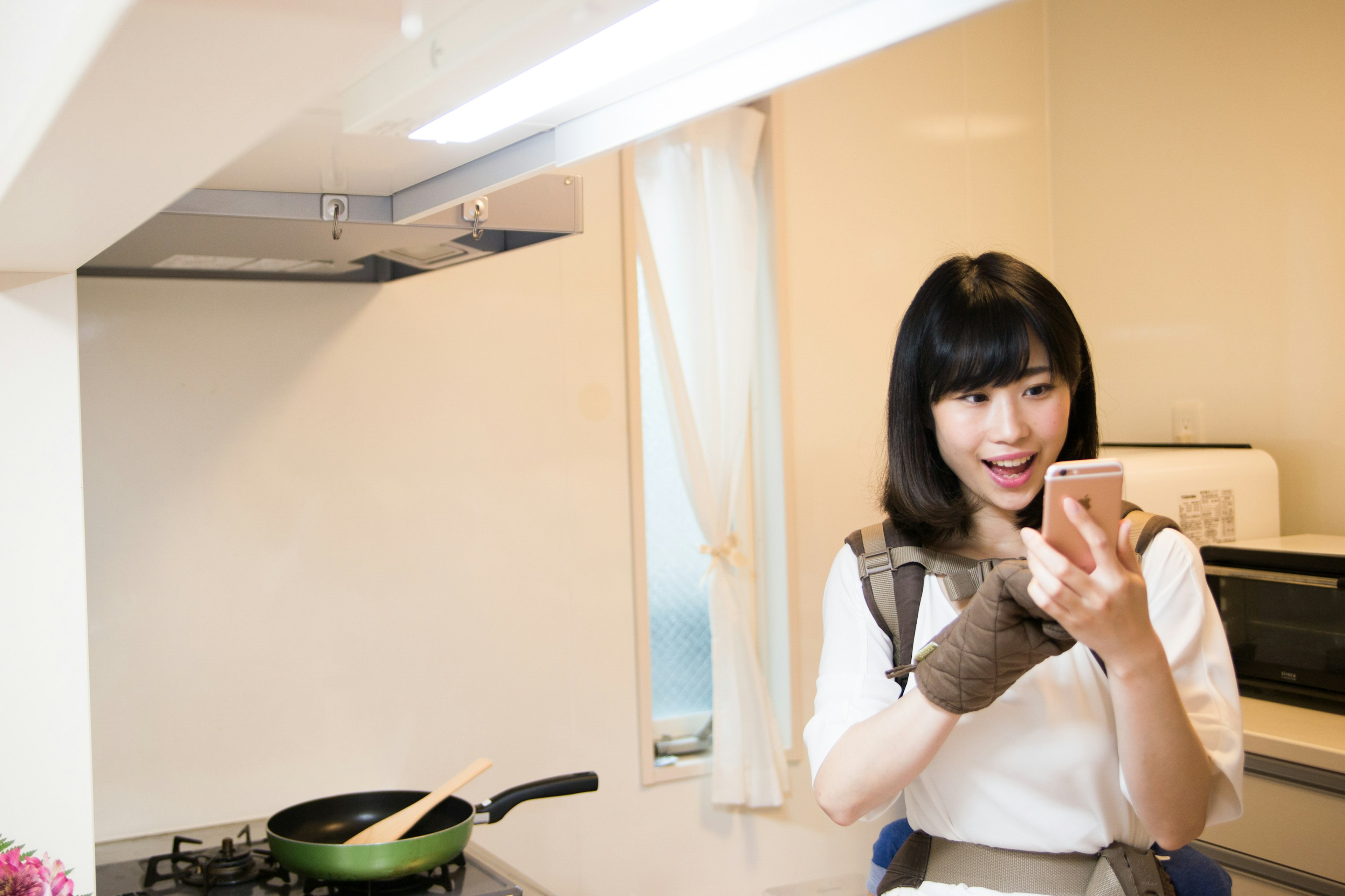 Woman in a kitchen looking at a smartphone