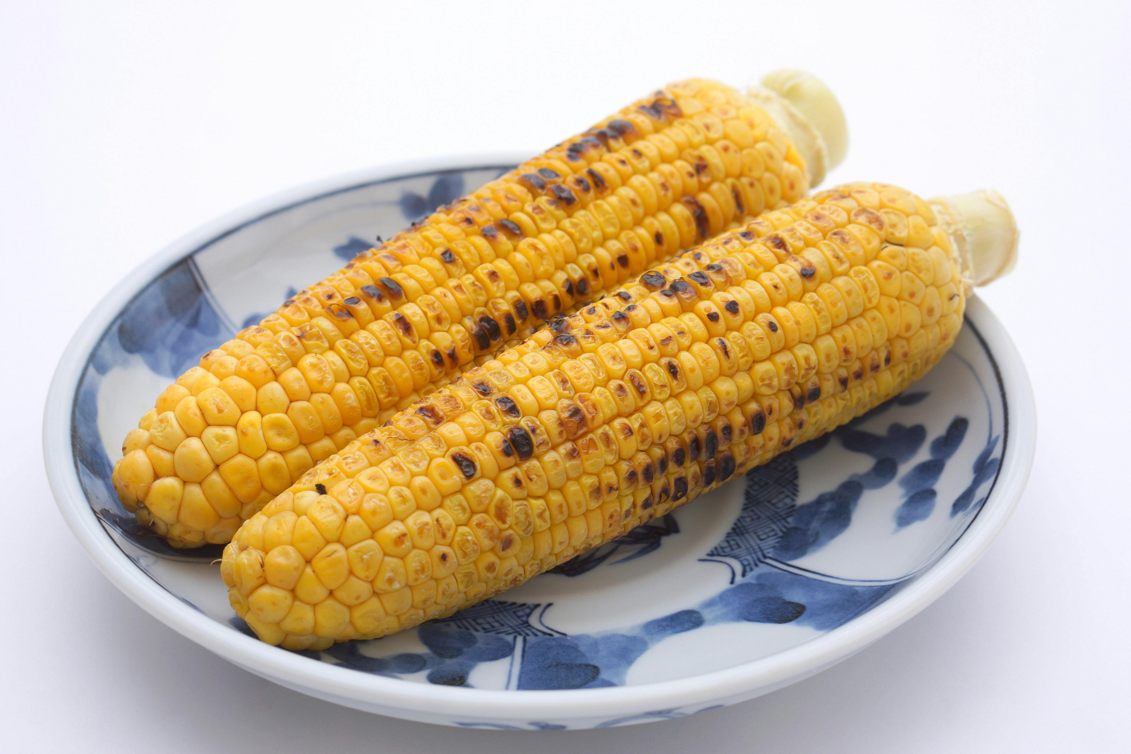 Grilled corn on the cob served on a decorative plate