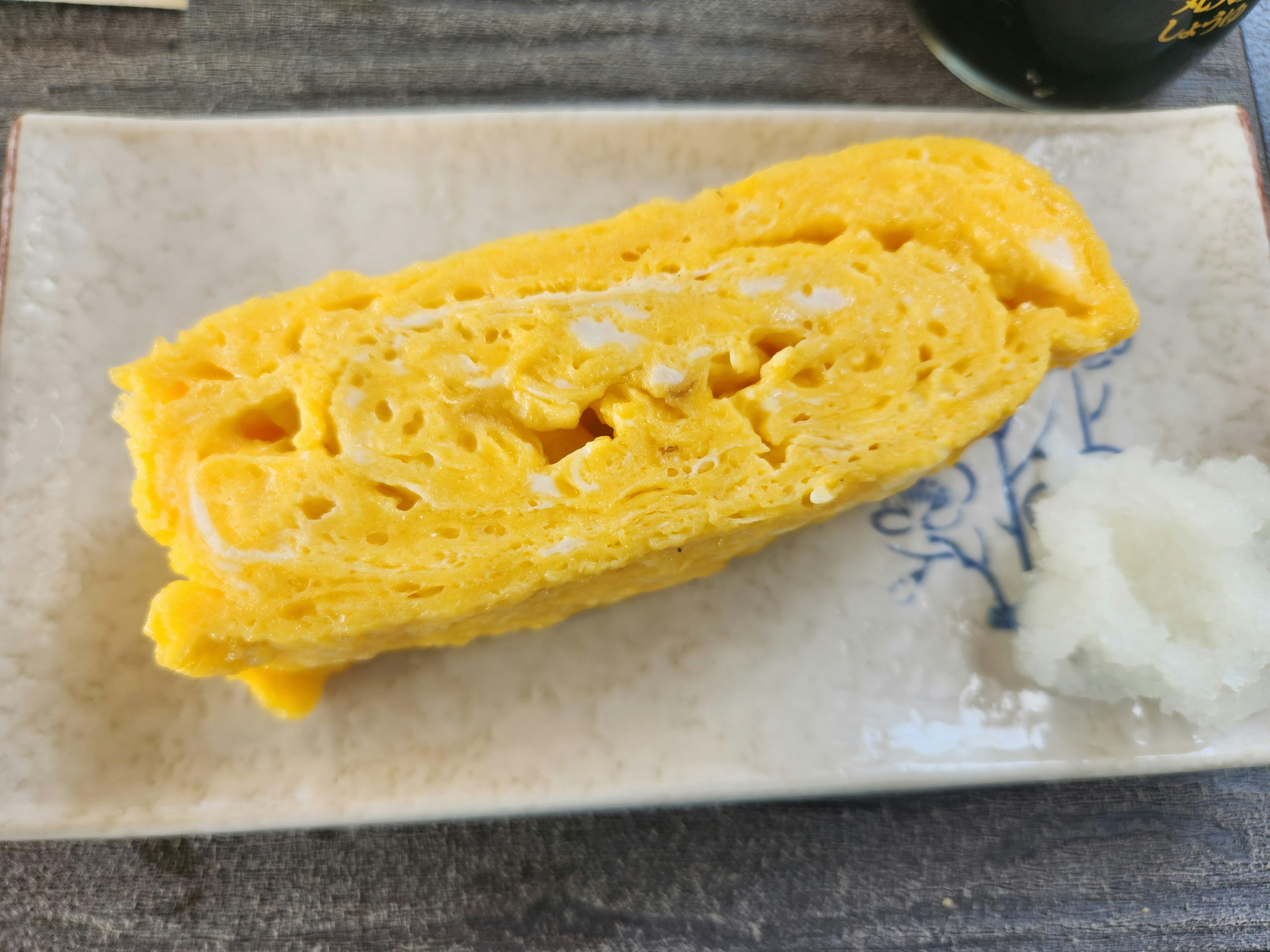 Omelet Jepang yang digulung disajikan dengan indah dan tekstur lembut