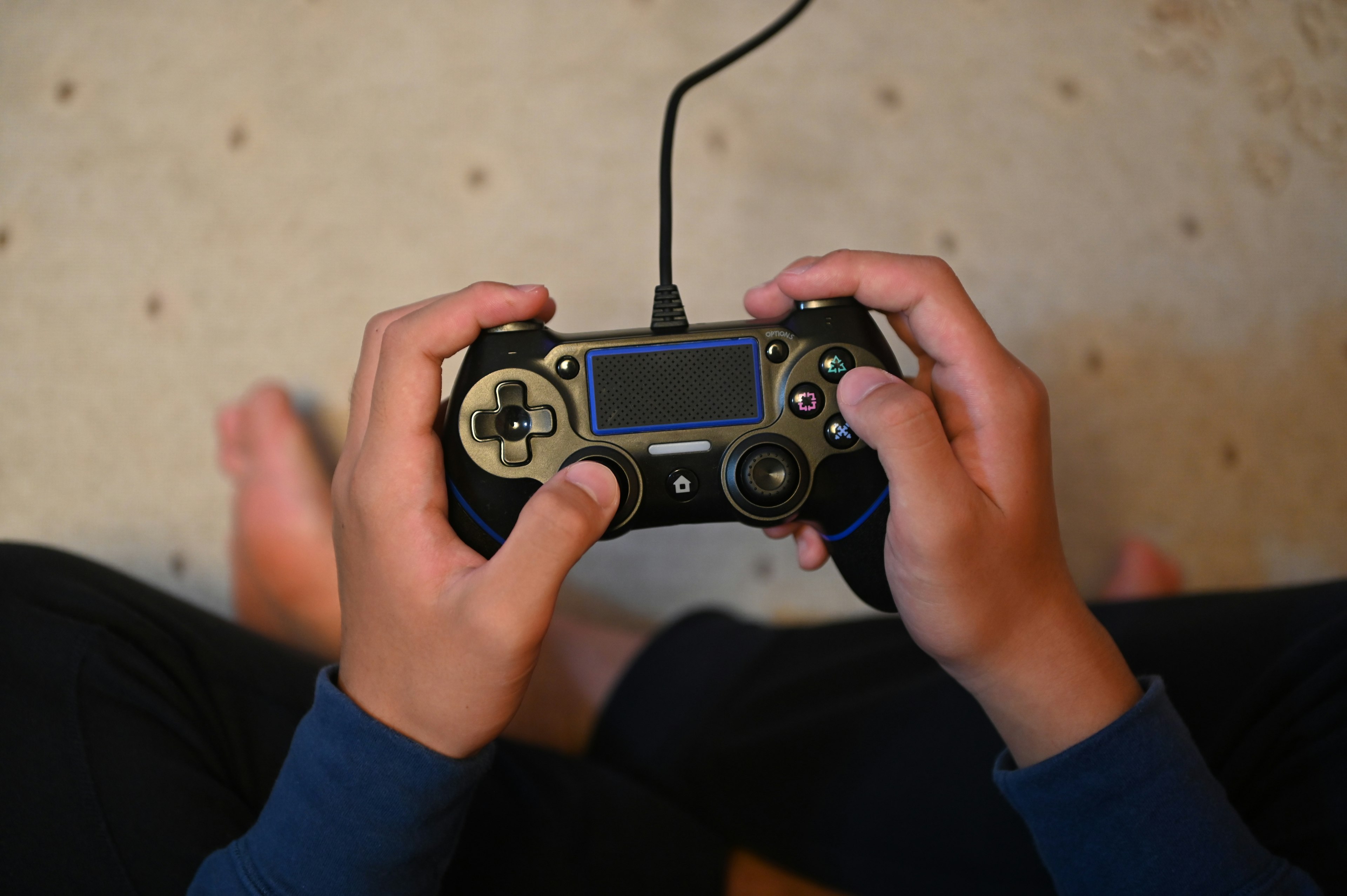 Mani di un bambino che tiene un controller di gioco