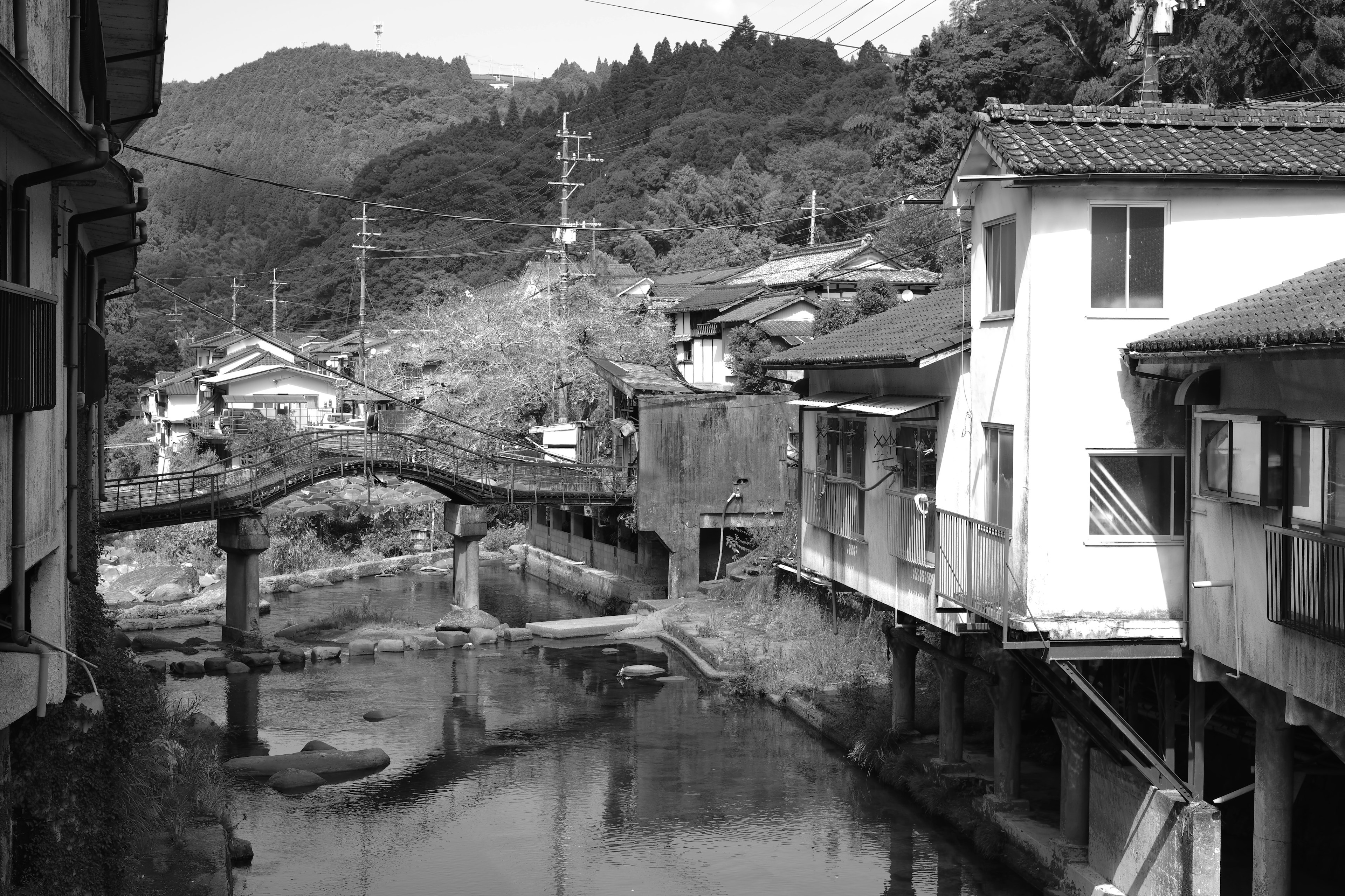 Schwarzweißfoto einer alten Stadt mit einem Fluss und traditionellen Gebäuden