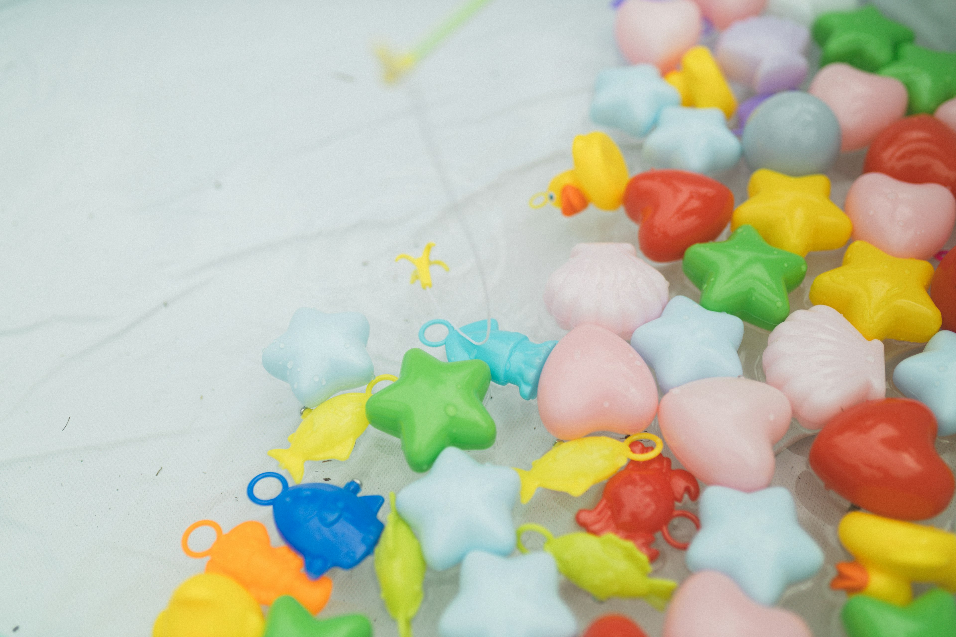 Jouets en plastique colorés en forme d'étoiles et de cœurs éparpillés sur une surface