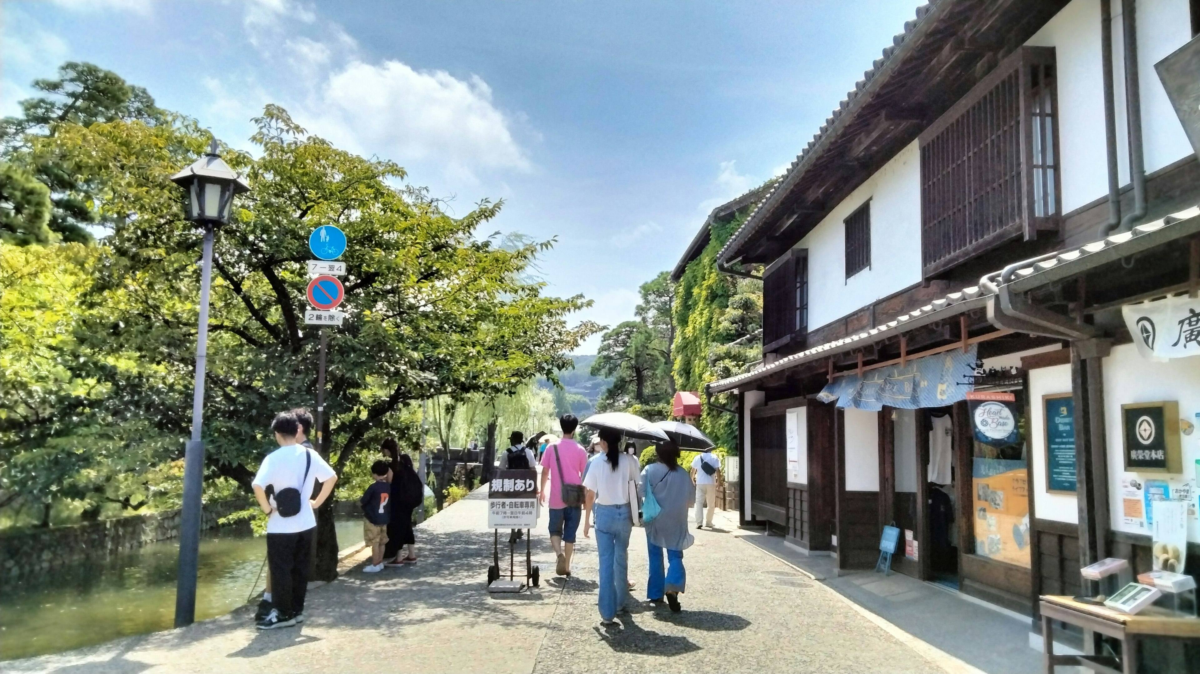 Turistas de pie en un paseo junto al río junto a edificios tradicionales