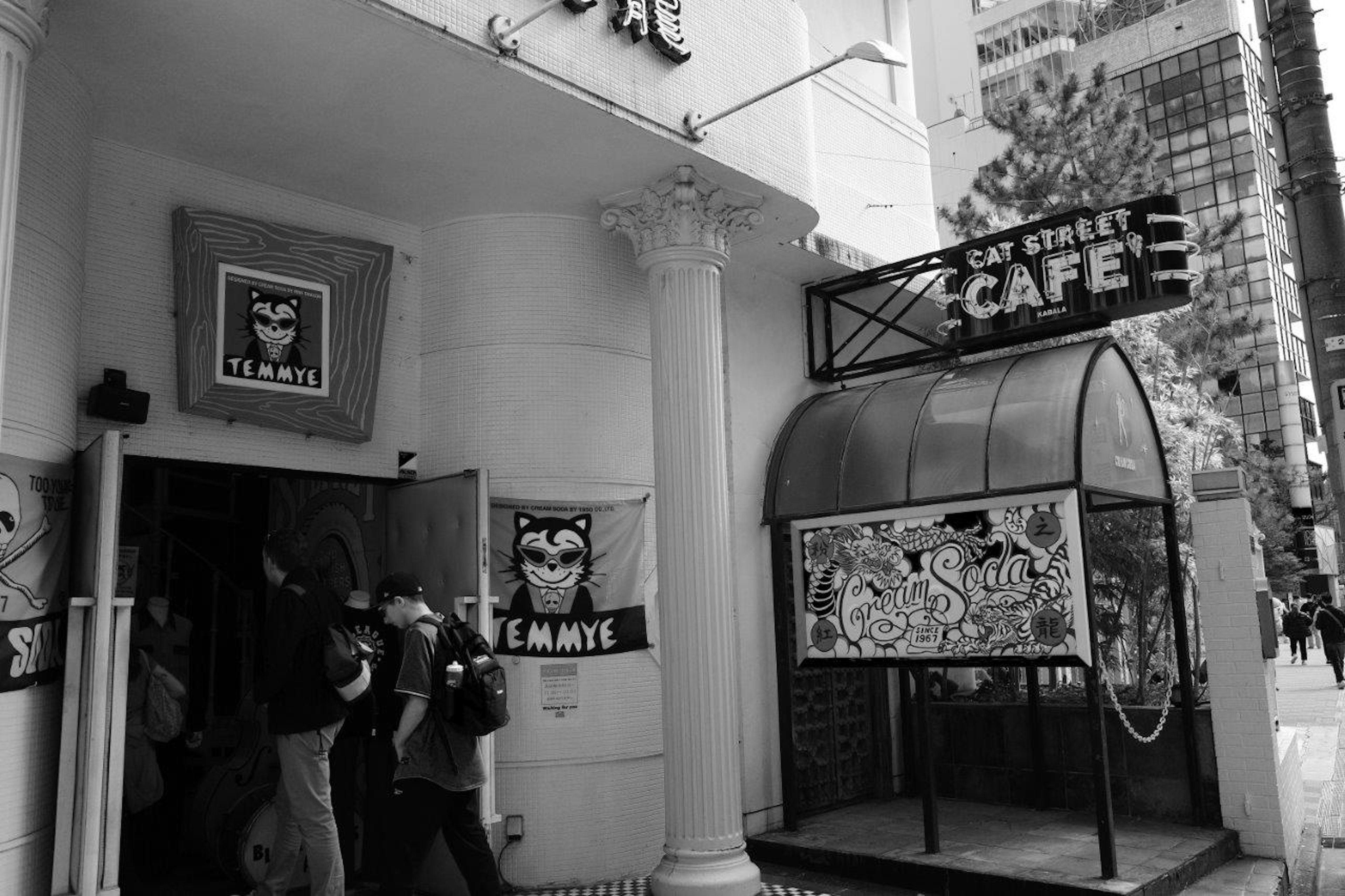 Café entrance with people gathered and striking black and white signage